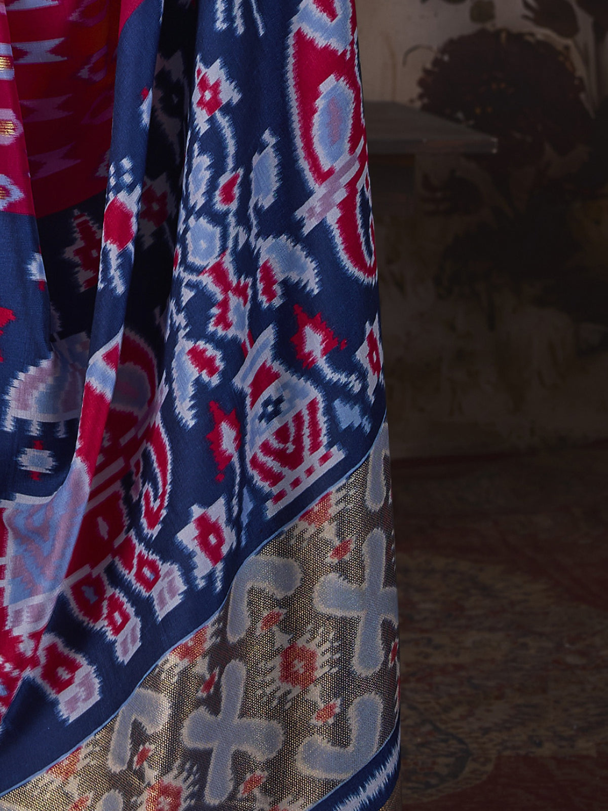Pallu detail of pink silk blend saree showing ikat resist-dyed pattern and embellished border