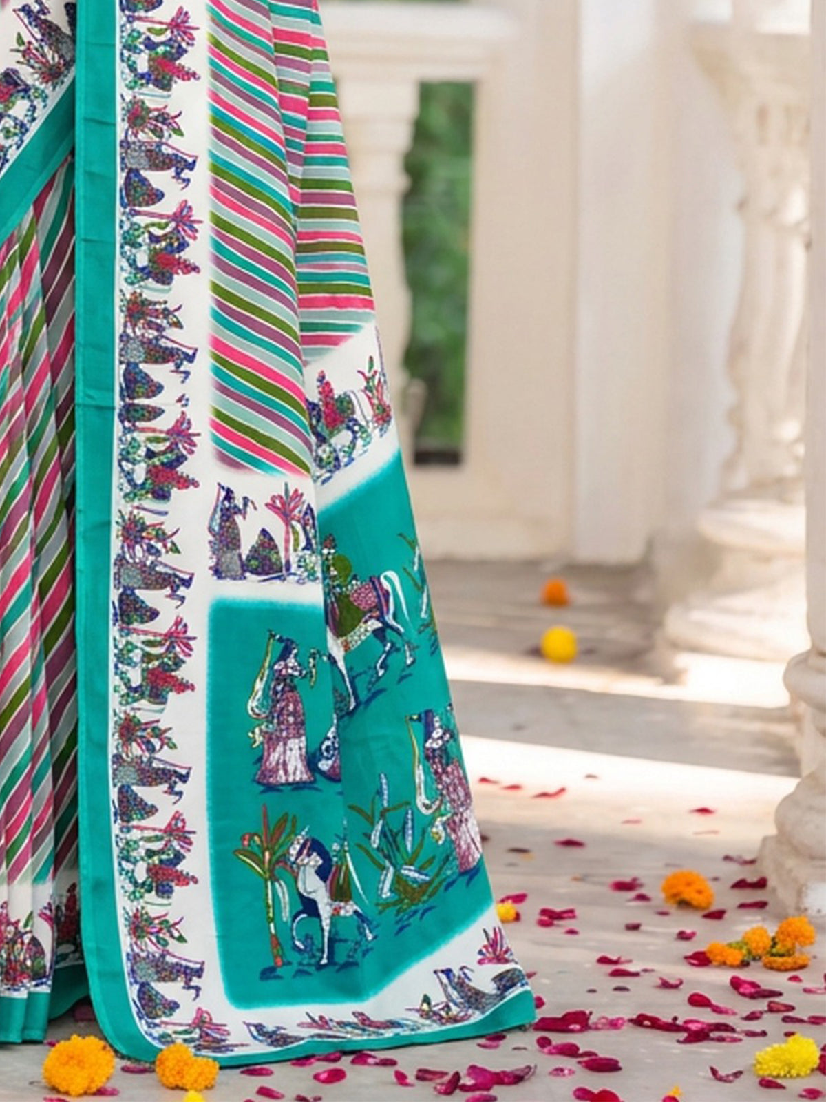 Pallu detail of teal green crepe saree showing striped pattern design and printed border