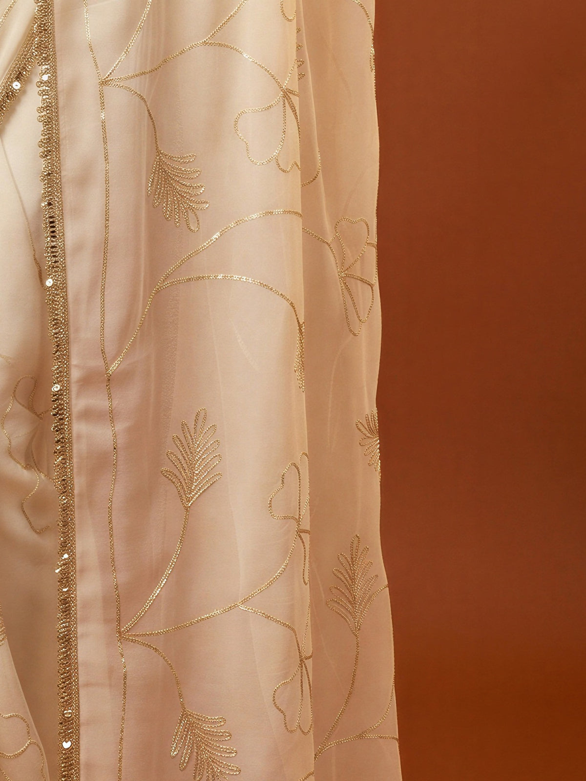 Pallu detail of white georgette saree showing embroidered motif work and embellished border
