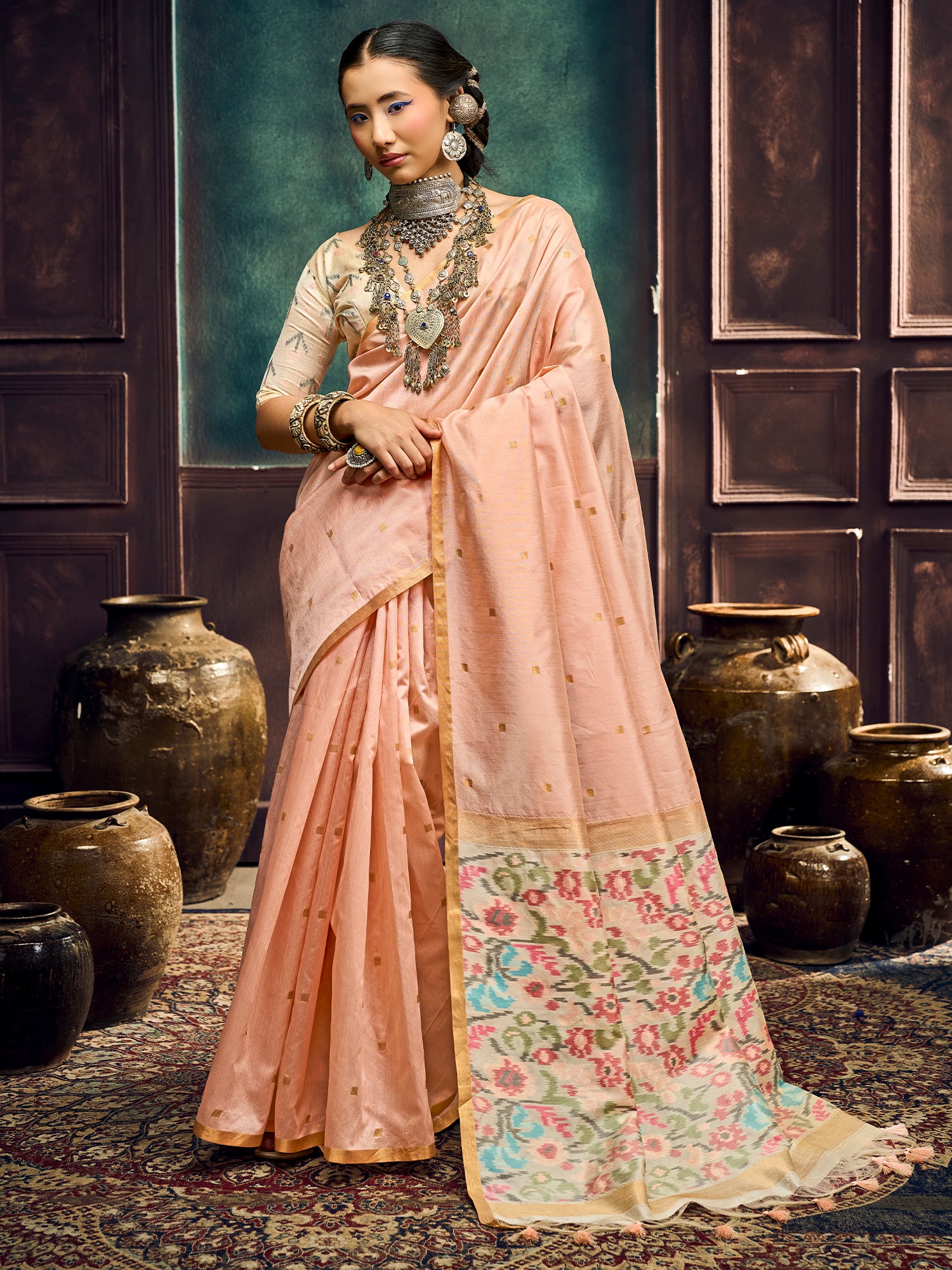 Woman wearing peach cotton silk saree with zari butta (metallic motif) work and peach blouse
