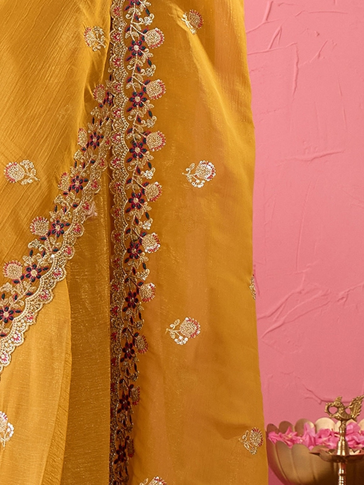 Pallu detail of mustard tissue saree showing ornamented surface design and zari border