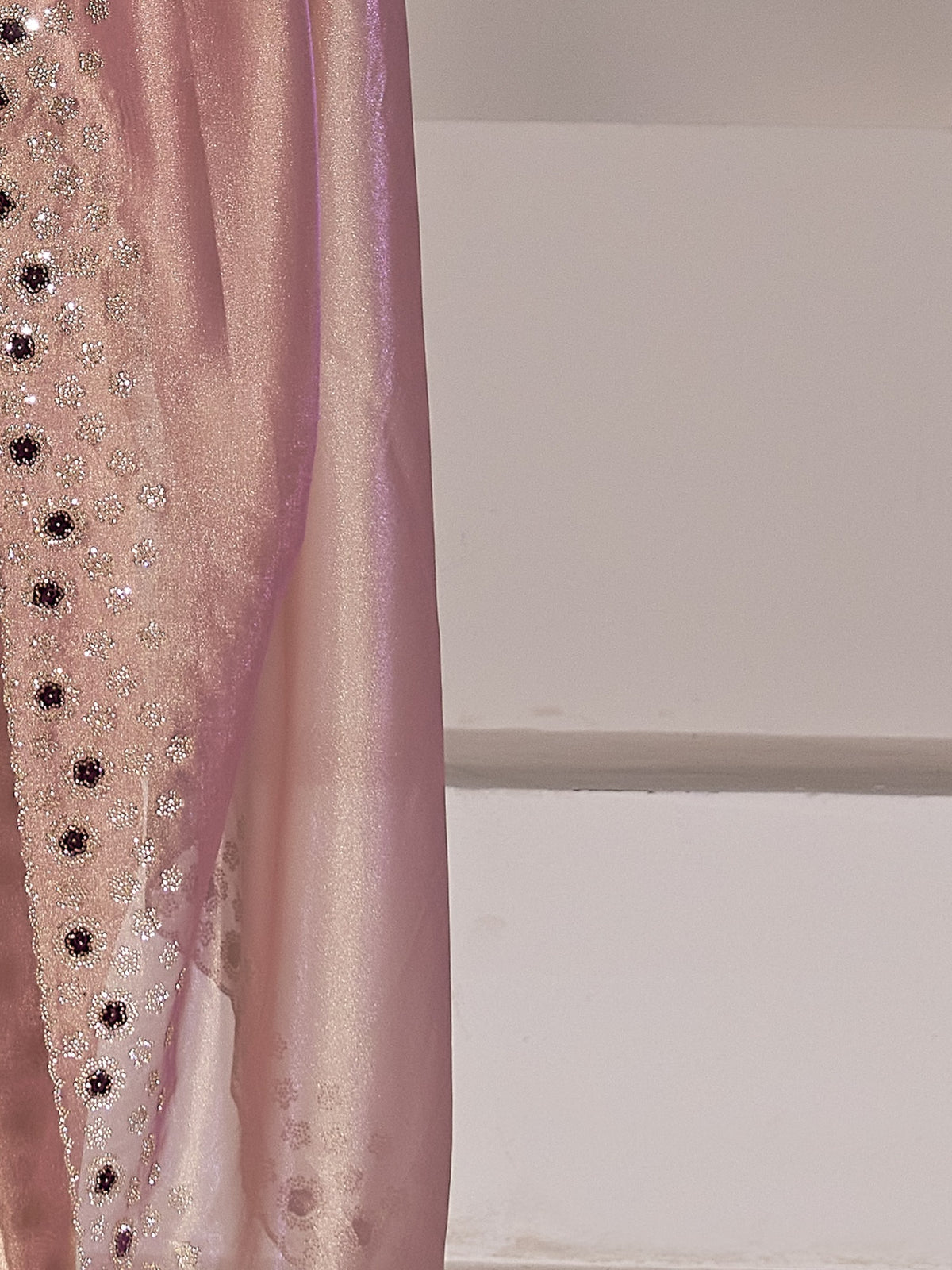 Pallu detail of mauve organza saree showing applique design and scallop border