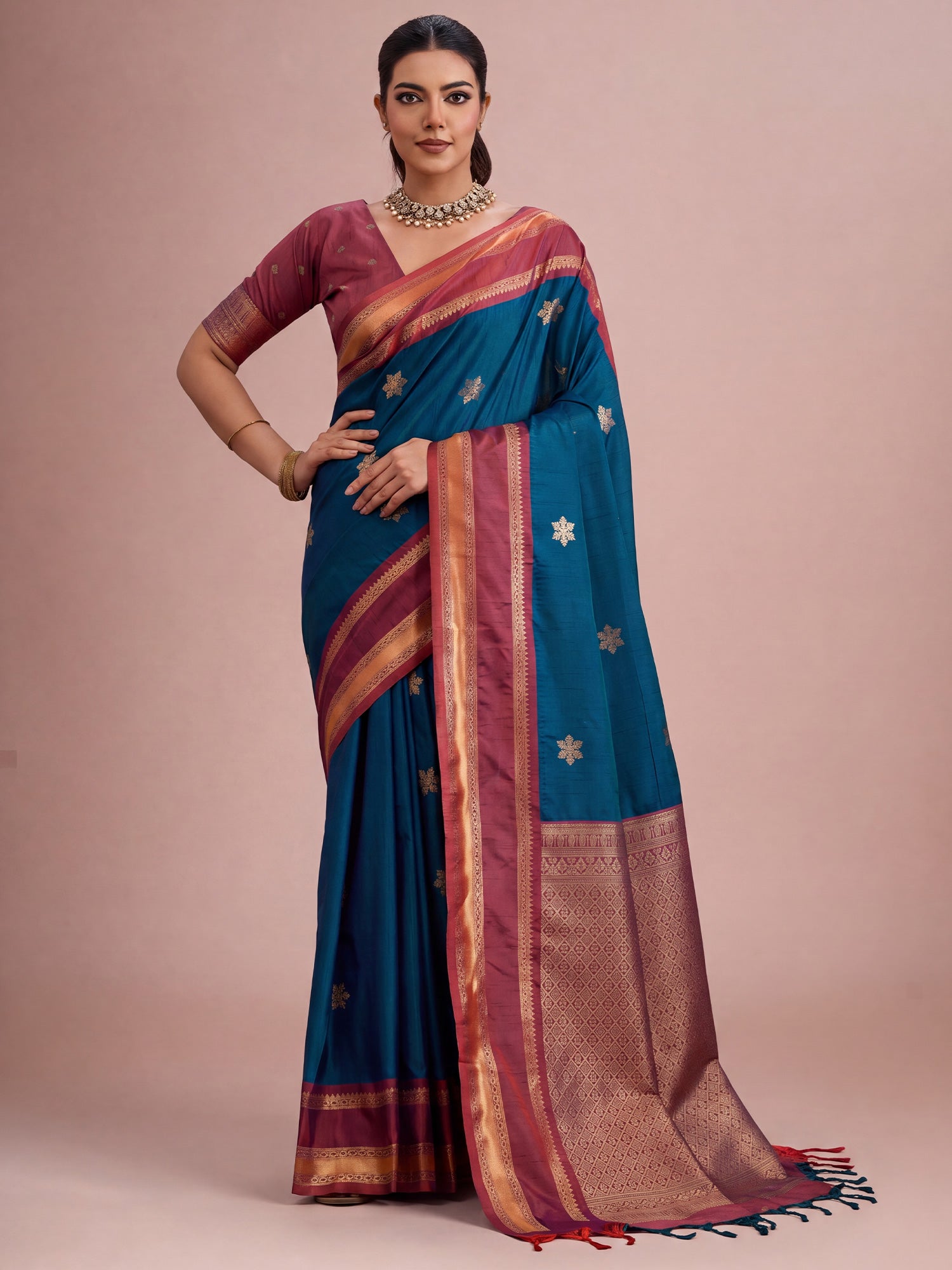 Woman wearing blue tussar silk saree with traditional indian motif work and maroon blouse