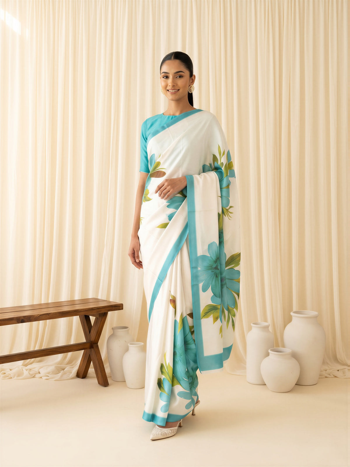 Woman wearing turquoise chiffon saree with all-over floral design and teal green blouse