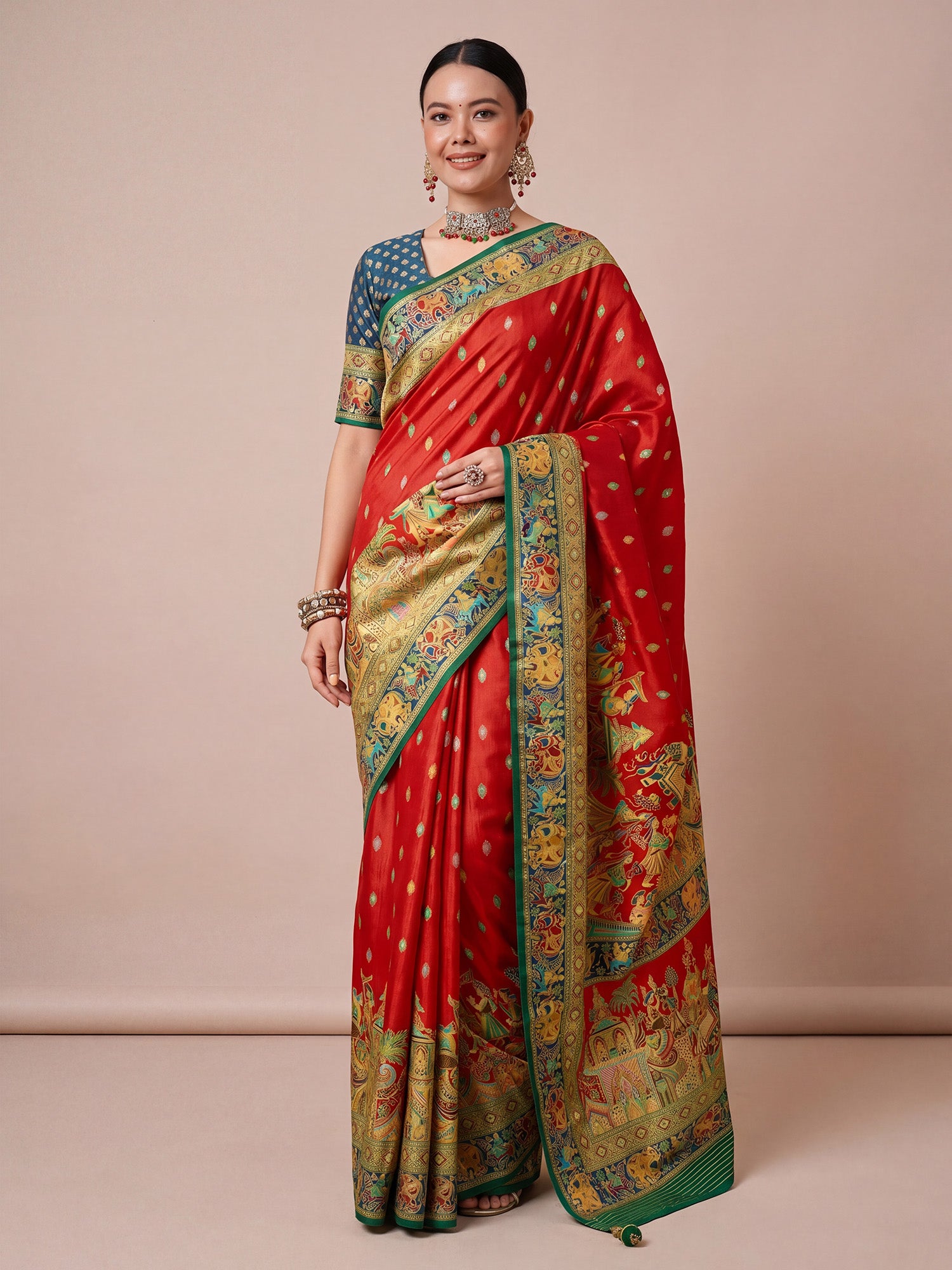 Woman wearing red viscose saree with metallic foil print work and teal blue blouse