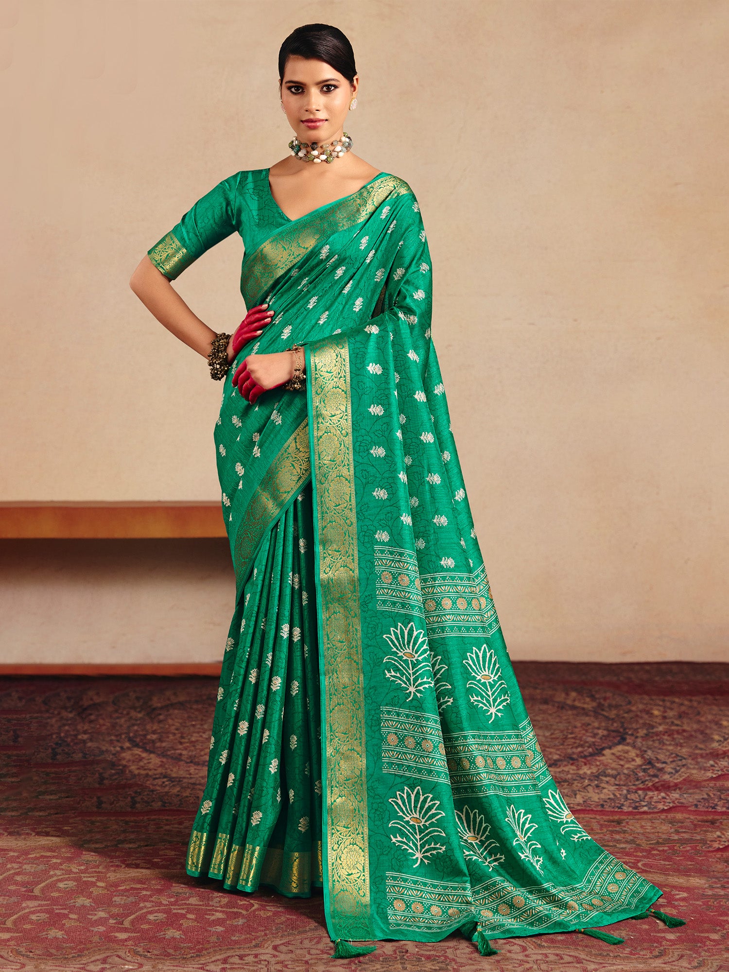 Woman wearing teal green tussar silk saree with traditional indian motif work and teal green blouse
