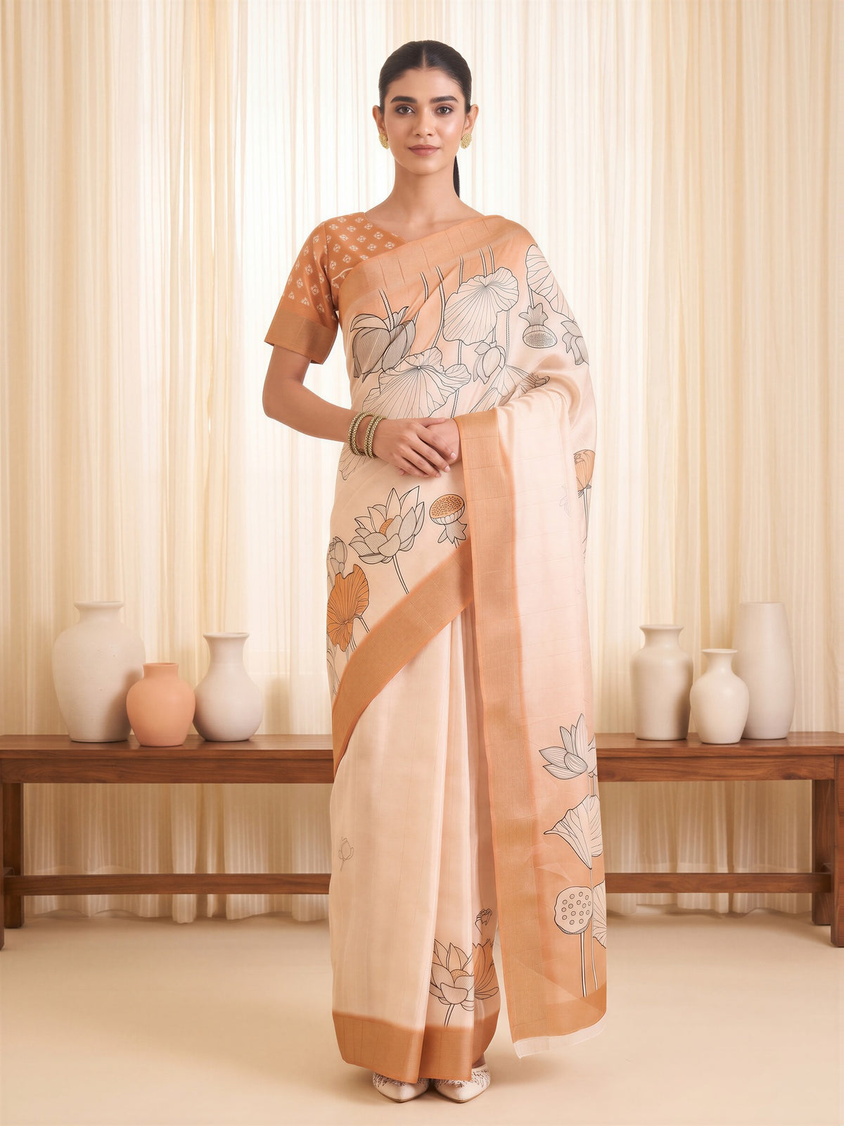 Woman wearing white satin silk saree with traditional indian motif work and orange blouse