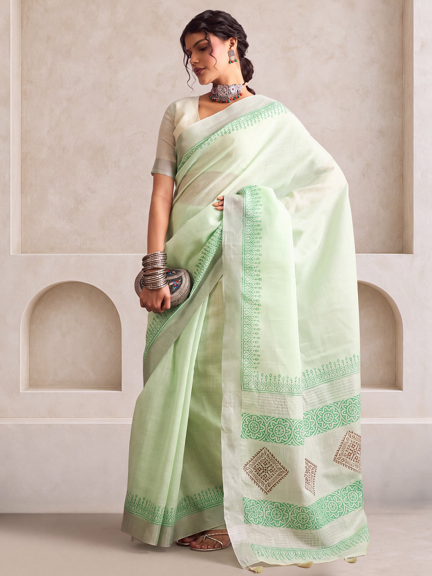 Woman wearing turquoise linen saree with bagh block-print motif work and turquoise blouse