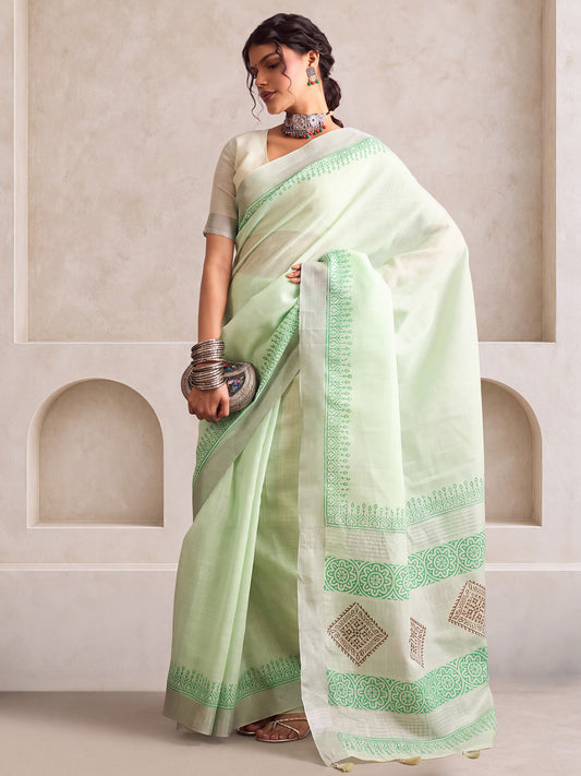 Woman wearing turquoise linen saree with bagh block-print motif work and turquoise blouse