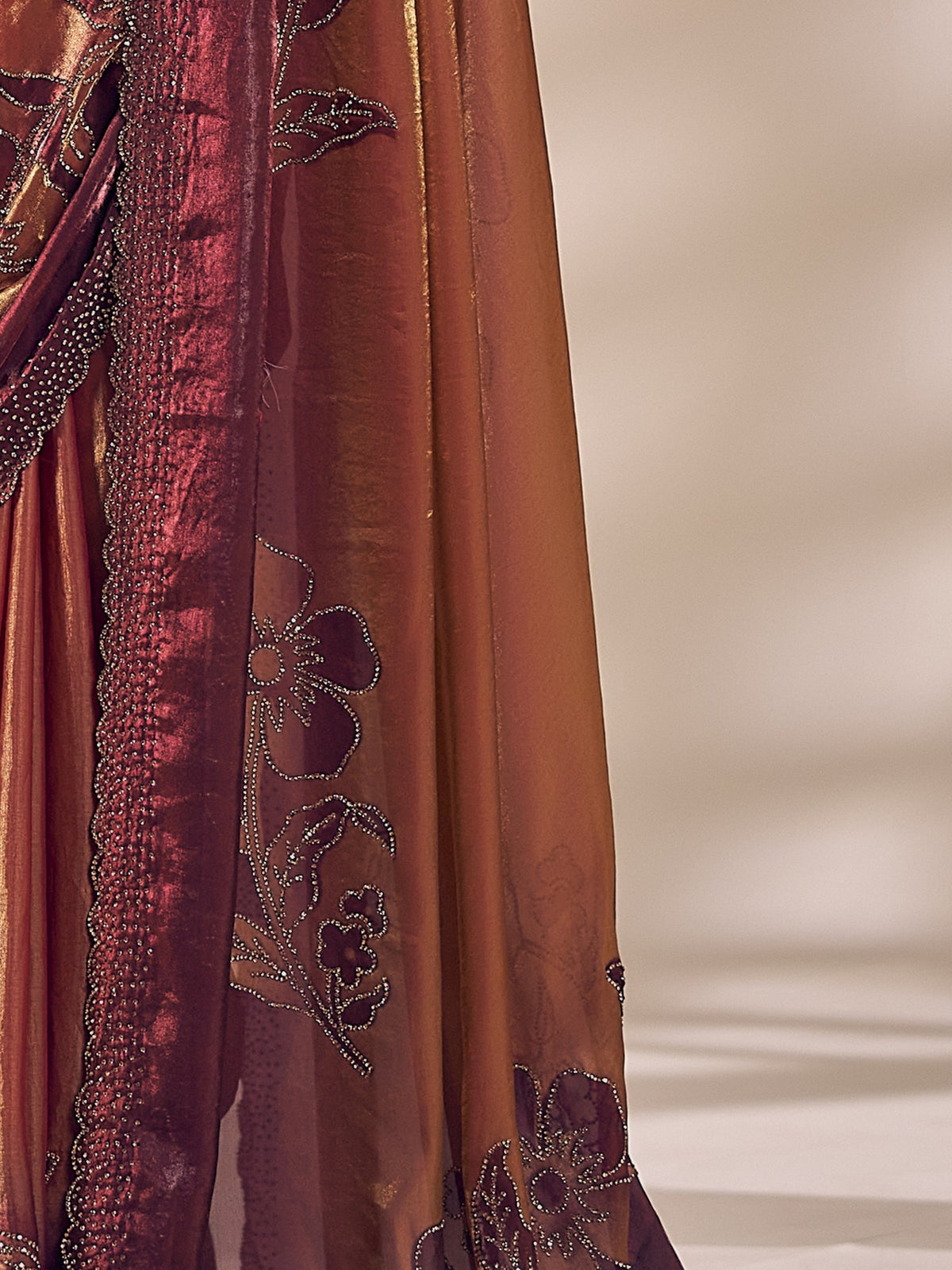 Pallu detail of rust satin silk saree showing ornamented surface design and scallop border