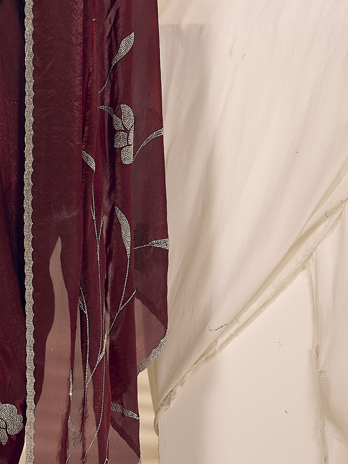 Pallu detail of maroon satin silk saree showing ornamented surface design and embellished border