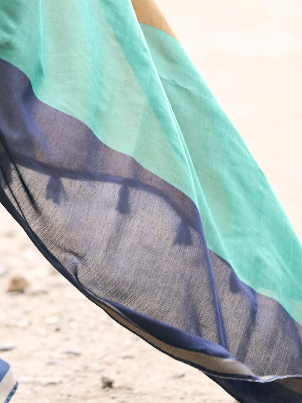 Pallu detail of teal green cotton blend saree showing colorblocked design and zari border