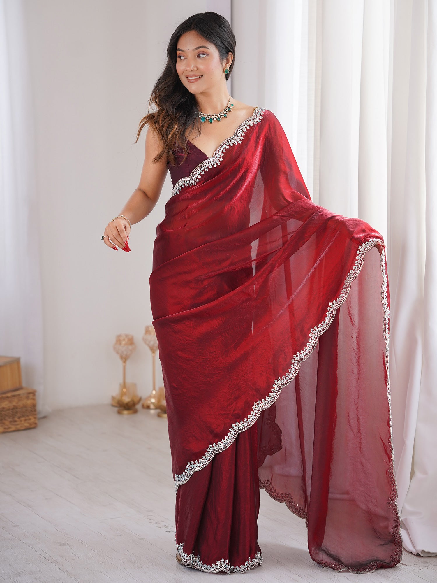 Woman wearing maroon silk blend saree with clean solid-tone finish and maroon blouse