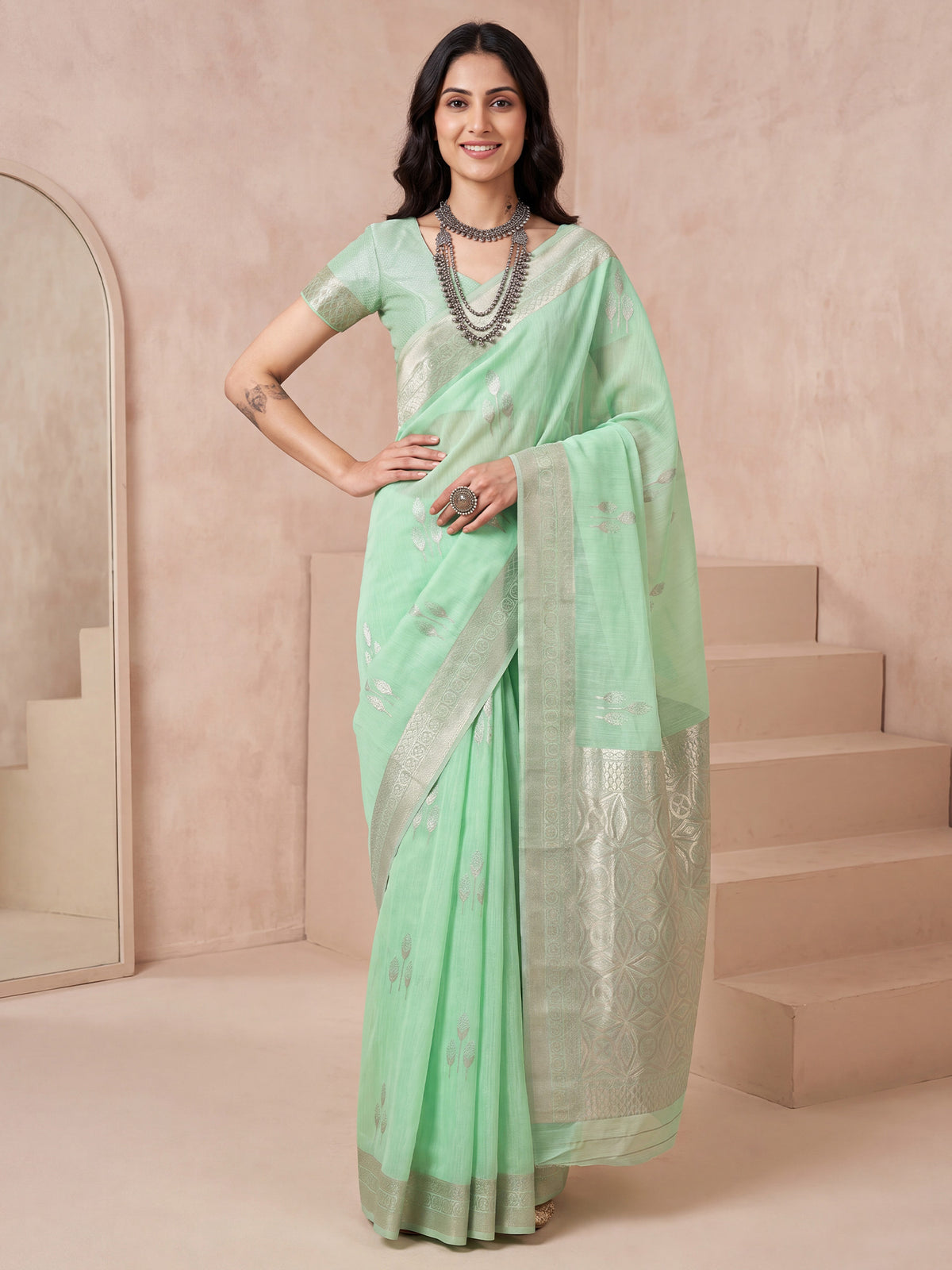 Woman wearing sea green linen saree with bagh block-print motif work and sea green blouse