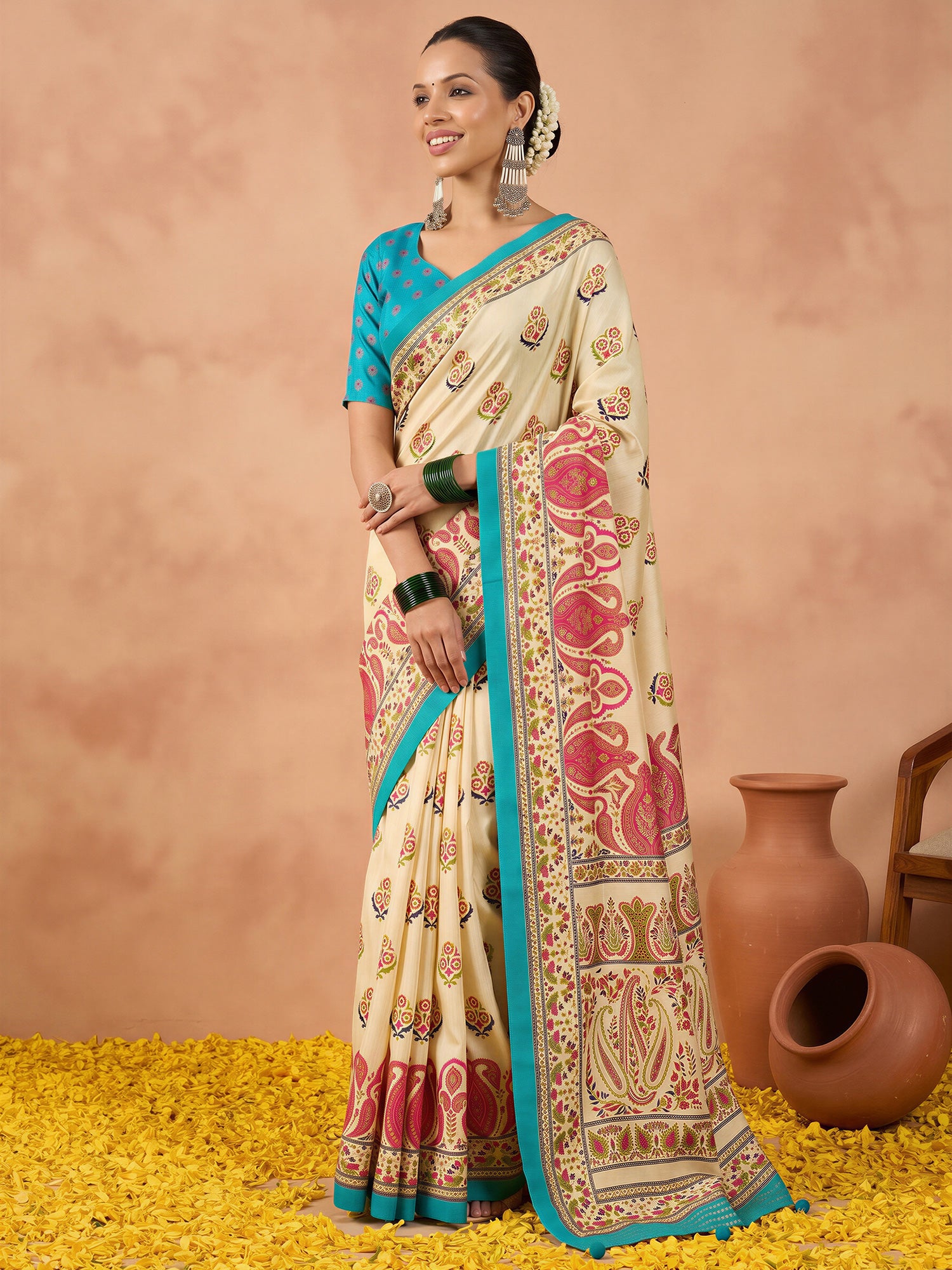 Woman wearing off white silk blend saree with metallic foil print work and teal blue blouse