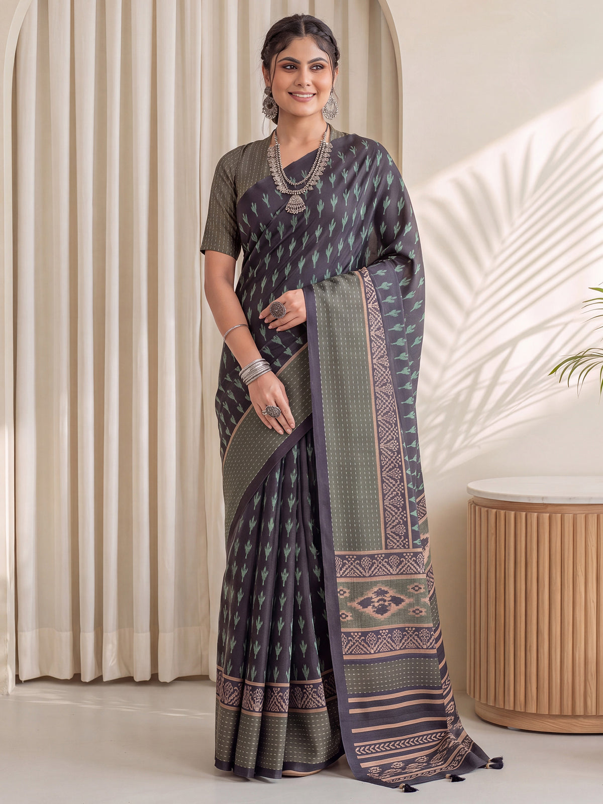 Woman wearing navy blue silk blend saree with traditional indian motif work and light green blouse