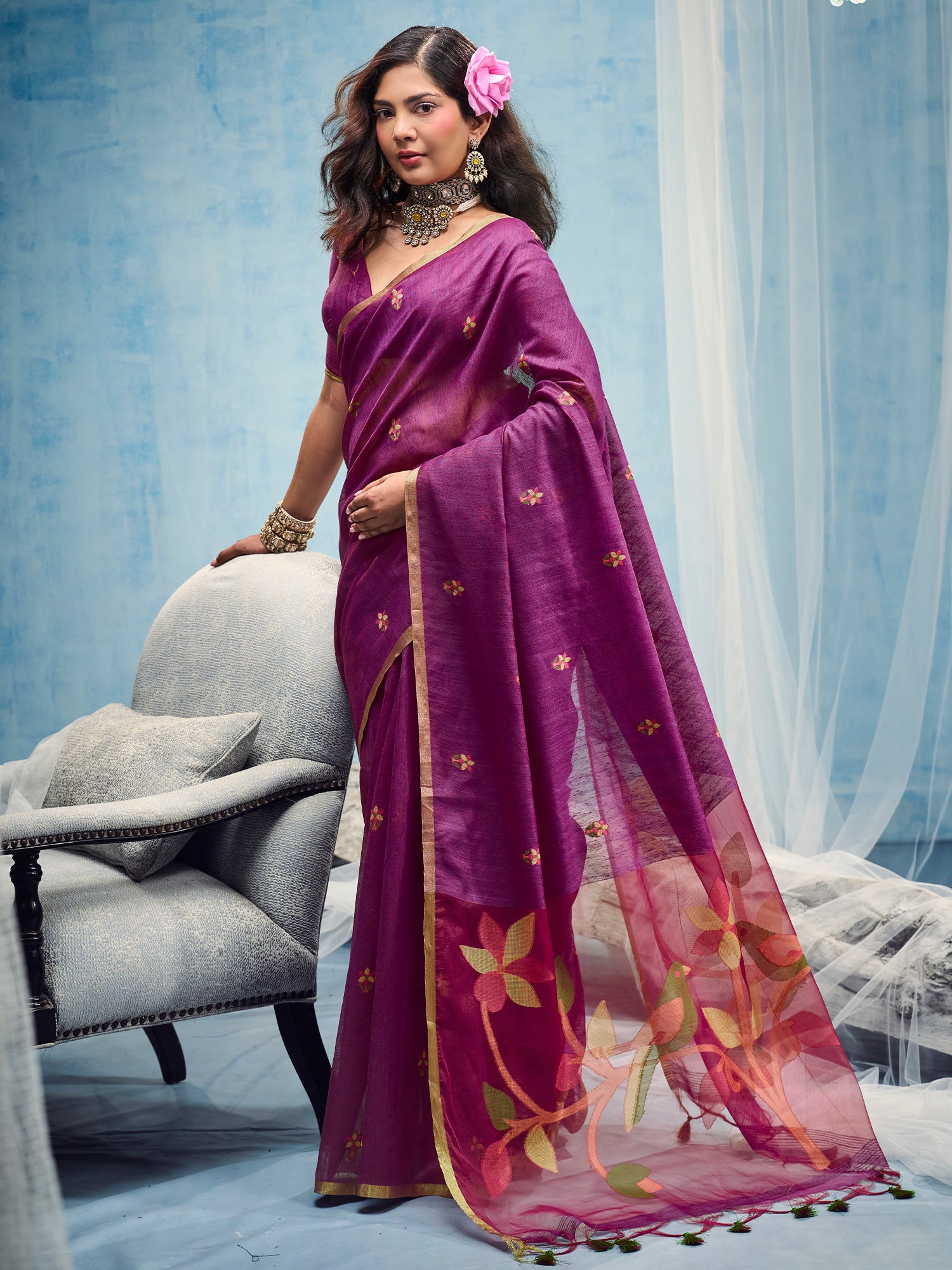 Woman wearing magenta muga cotton saree with embroidered motif work and magenta blouse