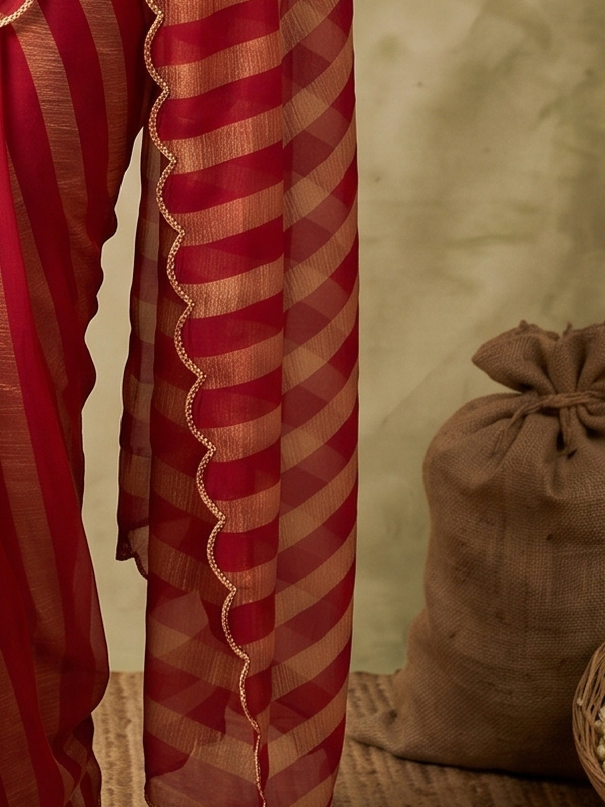 Pallu detail of red paper silk saree showing striped pattern design and embellished border
