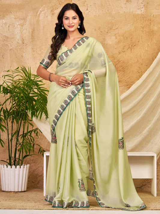 Woman wearing mint green georgette saree with peacock motif design and mint green blouse