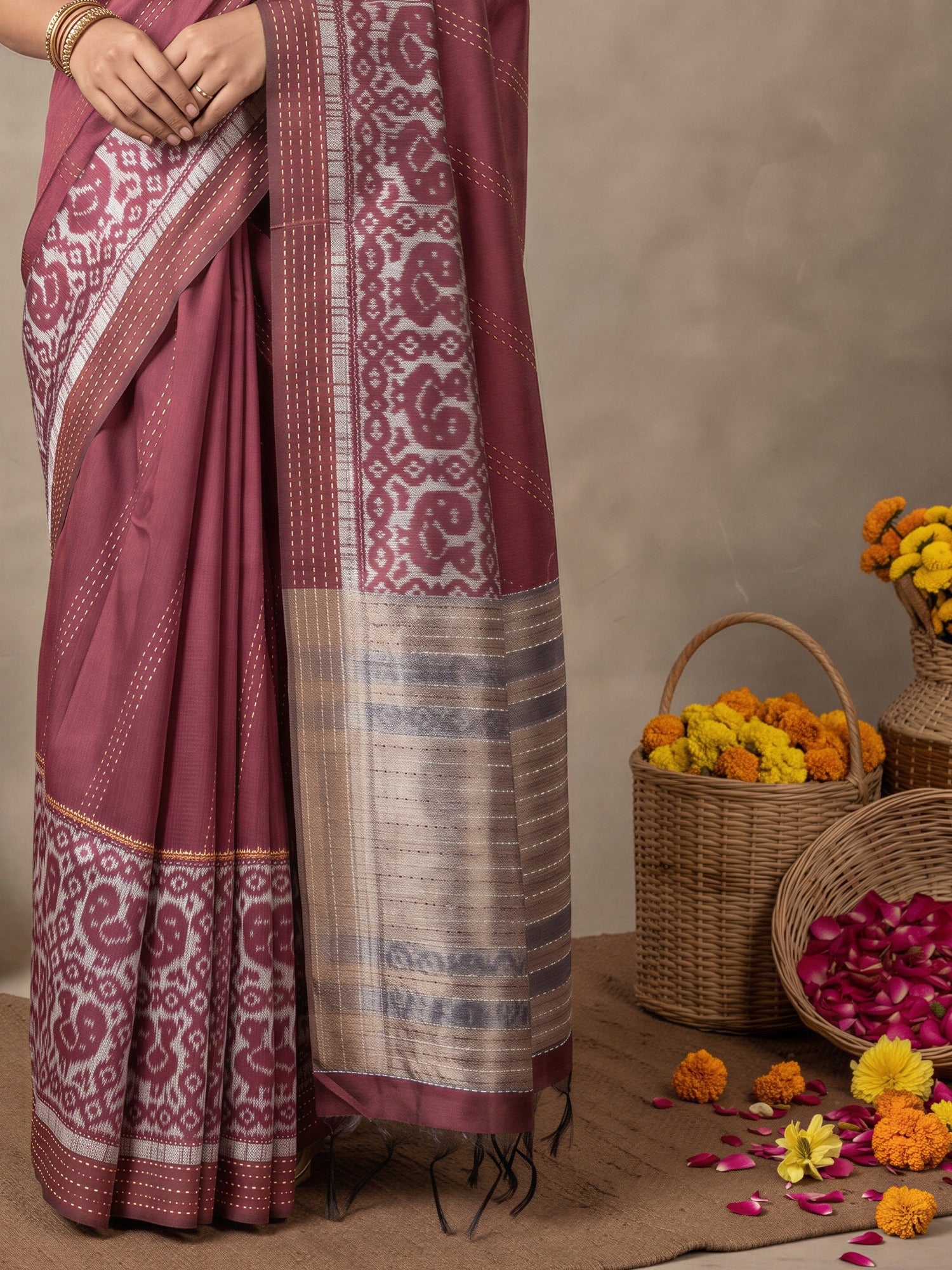 Pallu detail of burgundy silk cotton saree showing ikat resist-dyed pattern and embroidered border
