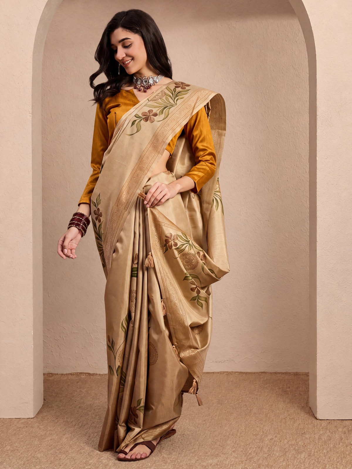 Woman wearing beige silk blend saree with hand-painted motif work and mustard blouse