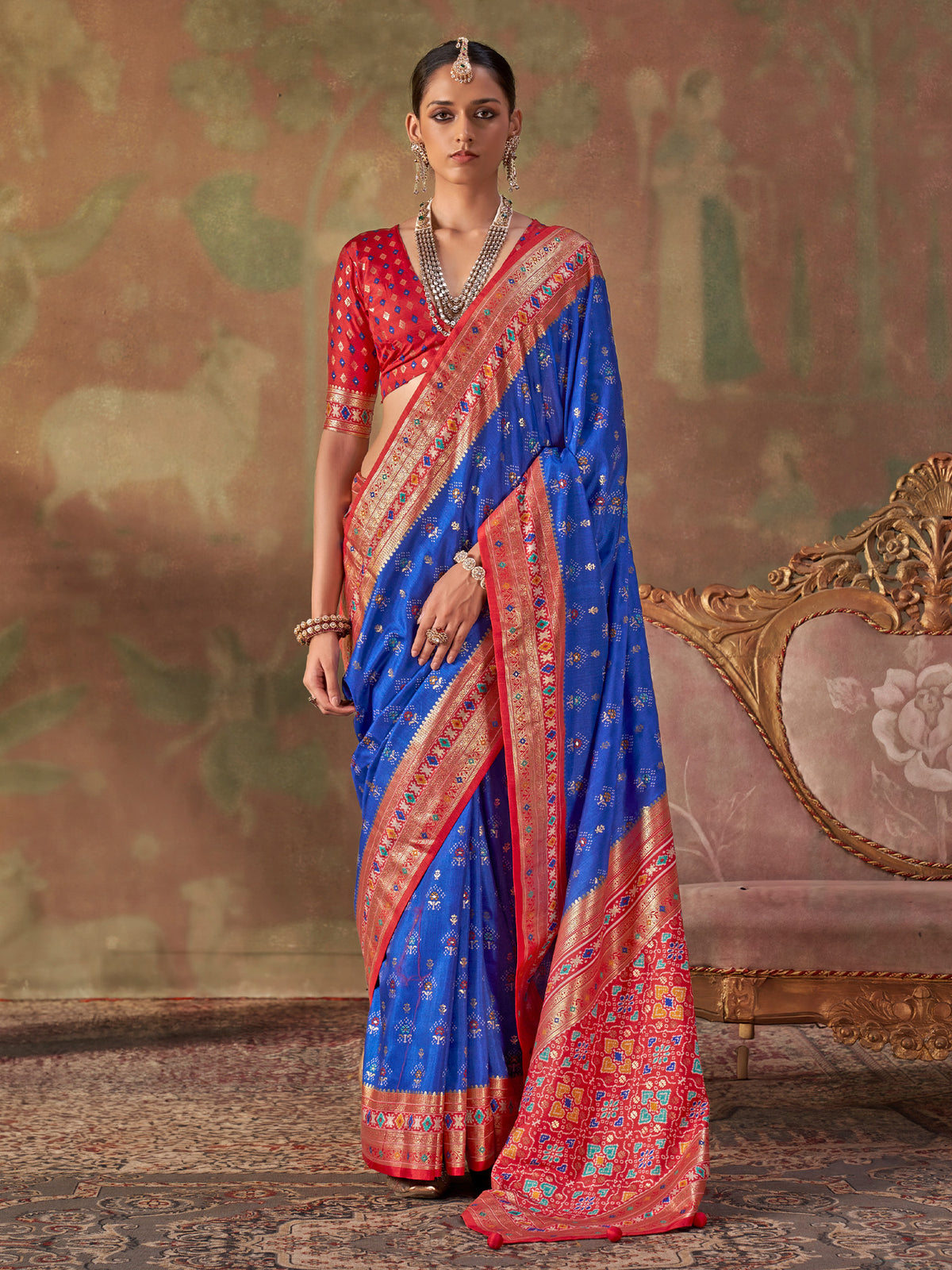 Woman wearing blue silk blend saree with traditional indian motif work and red blouse