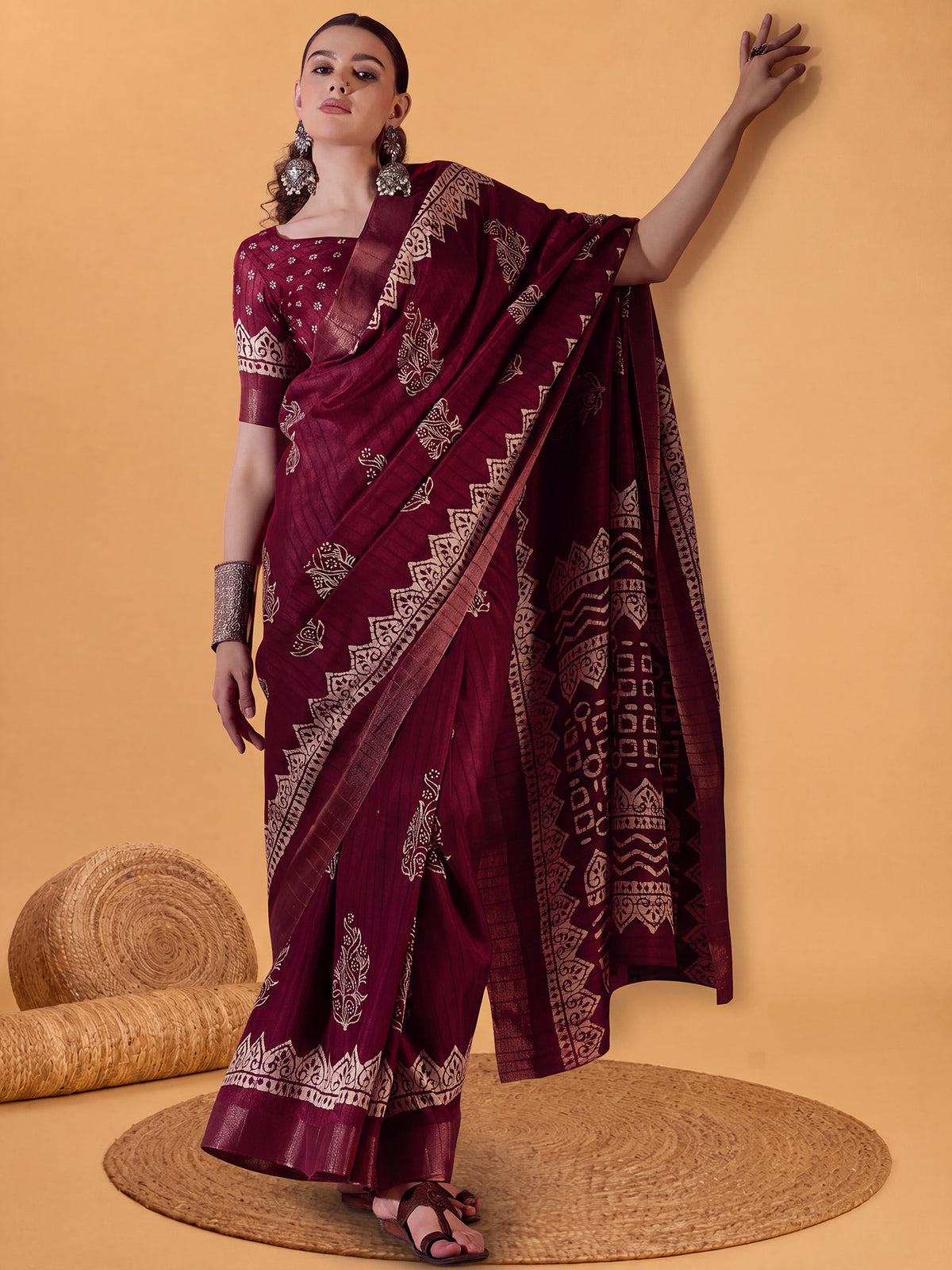 Woman wearing burgundy silk blend saree with dabu mud-resist print work and burgundy blouse