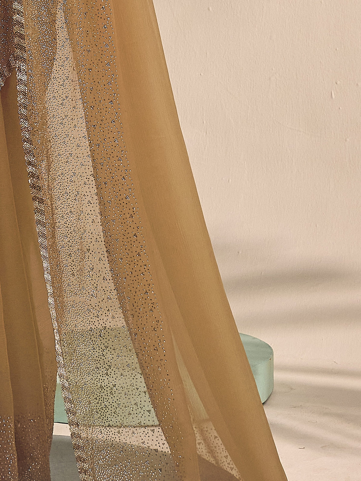 Pallu detail of olive chiffon saree showing ornamented surface design and embellished border