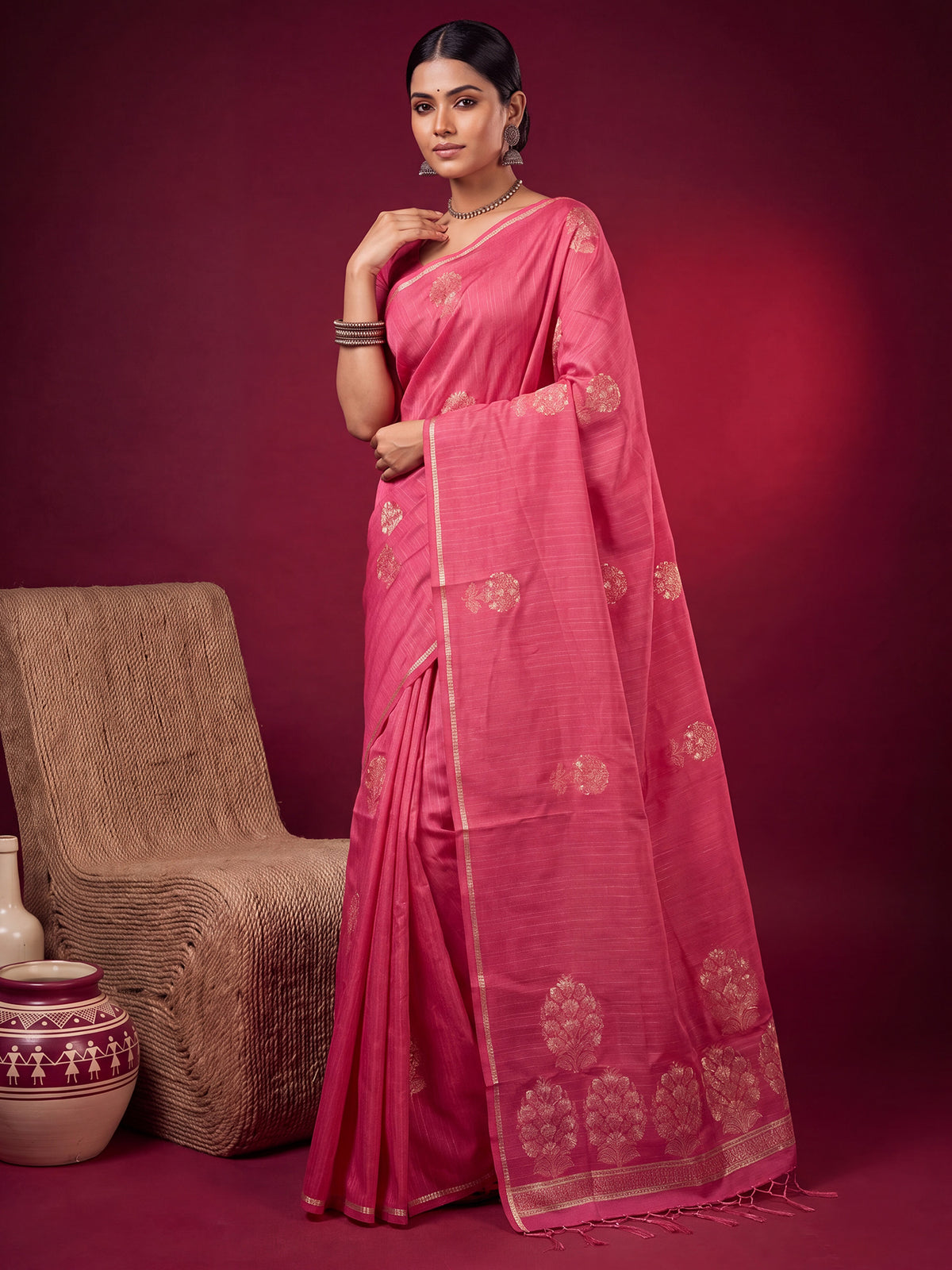 Woman wearing pink satin silk saree with zari butta (metallic motif) work and pink blouse