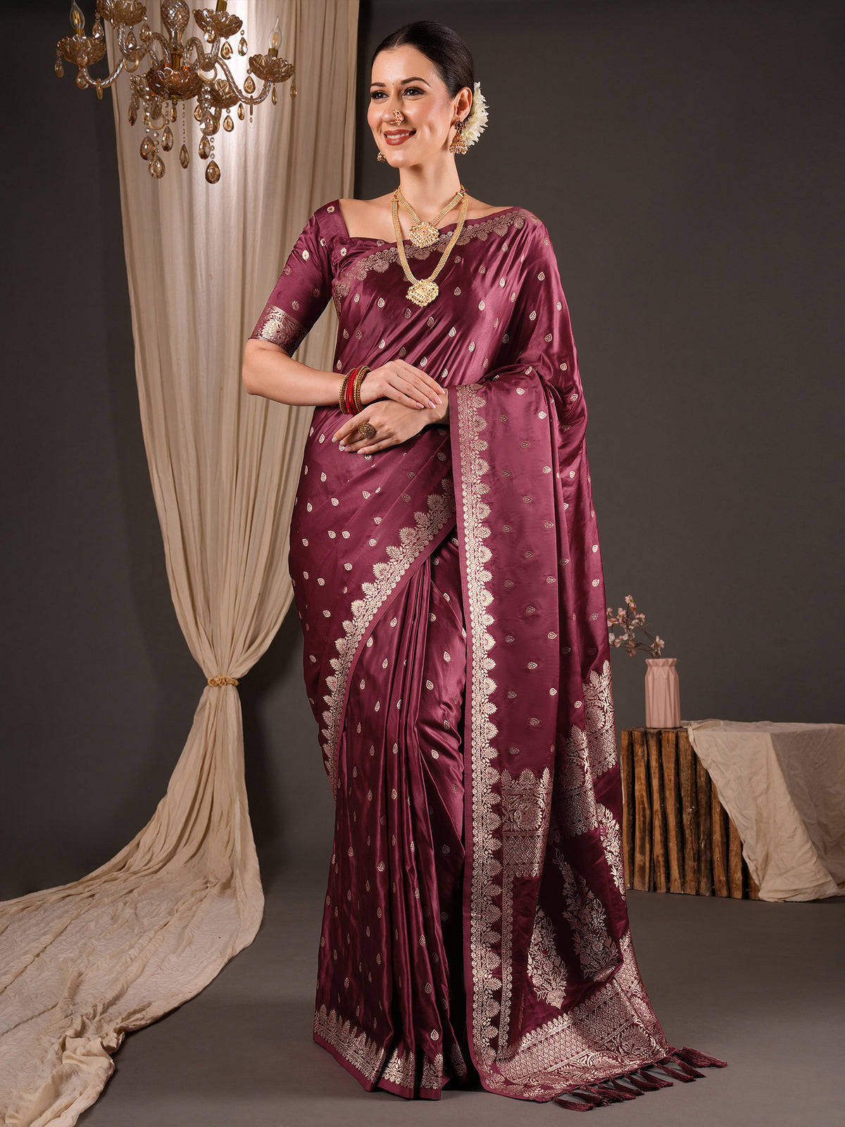 Woman wearing wine silk blend saree with zari butta (metallic motif) work and wine blouse