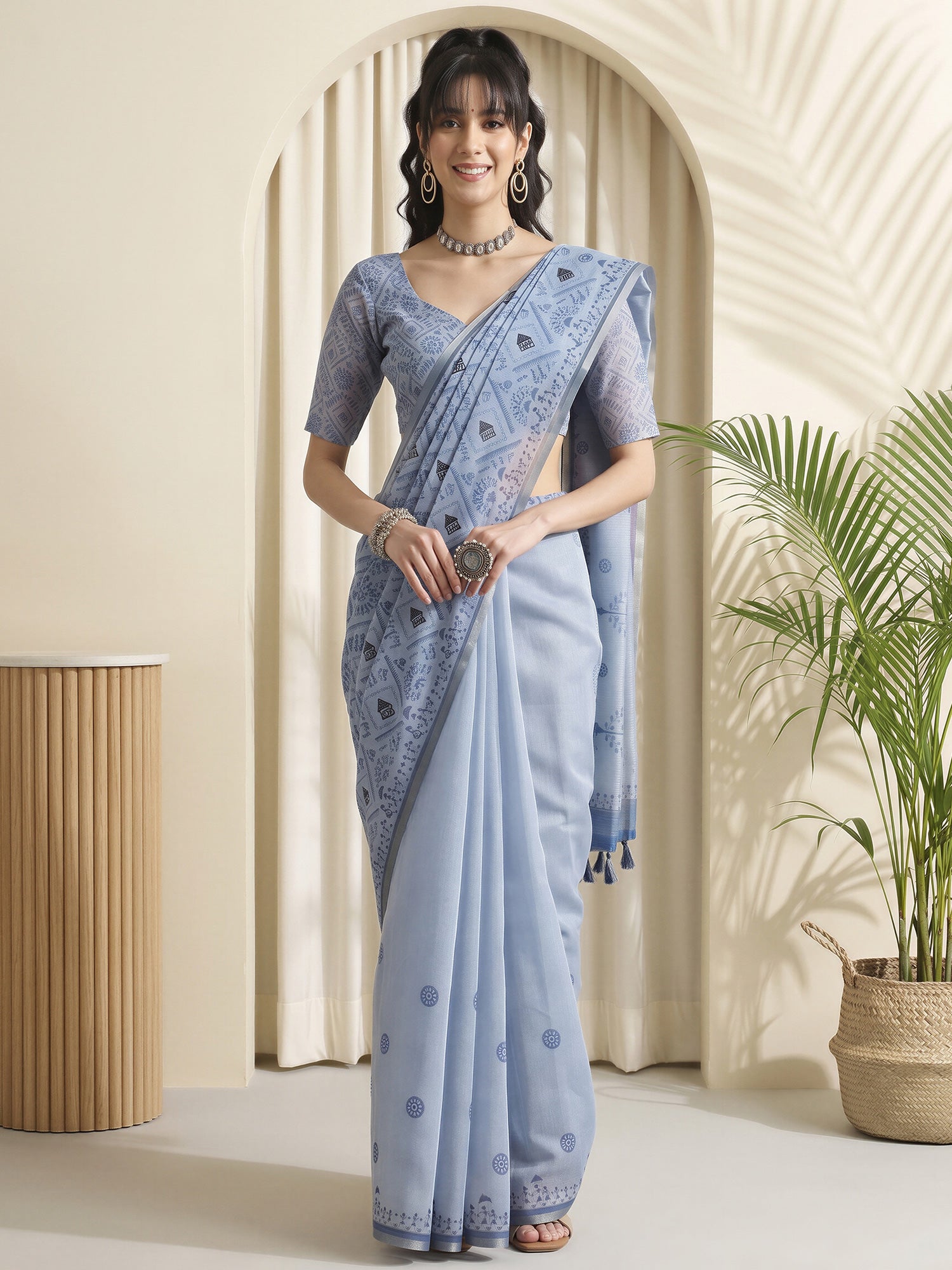 Woman wearing light blue cotton linen saree with warli folk-art figures and light blue blouse