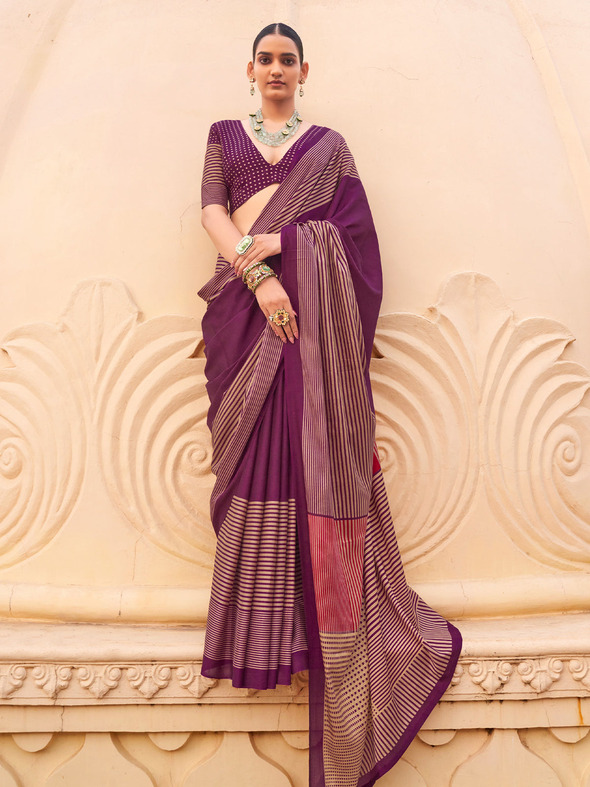 Woman wearing wine silk blend saree with striped pattern design and wine blouse