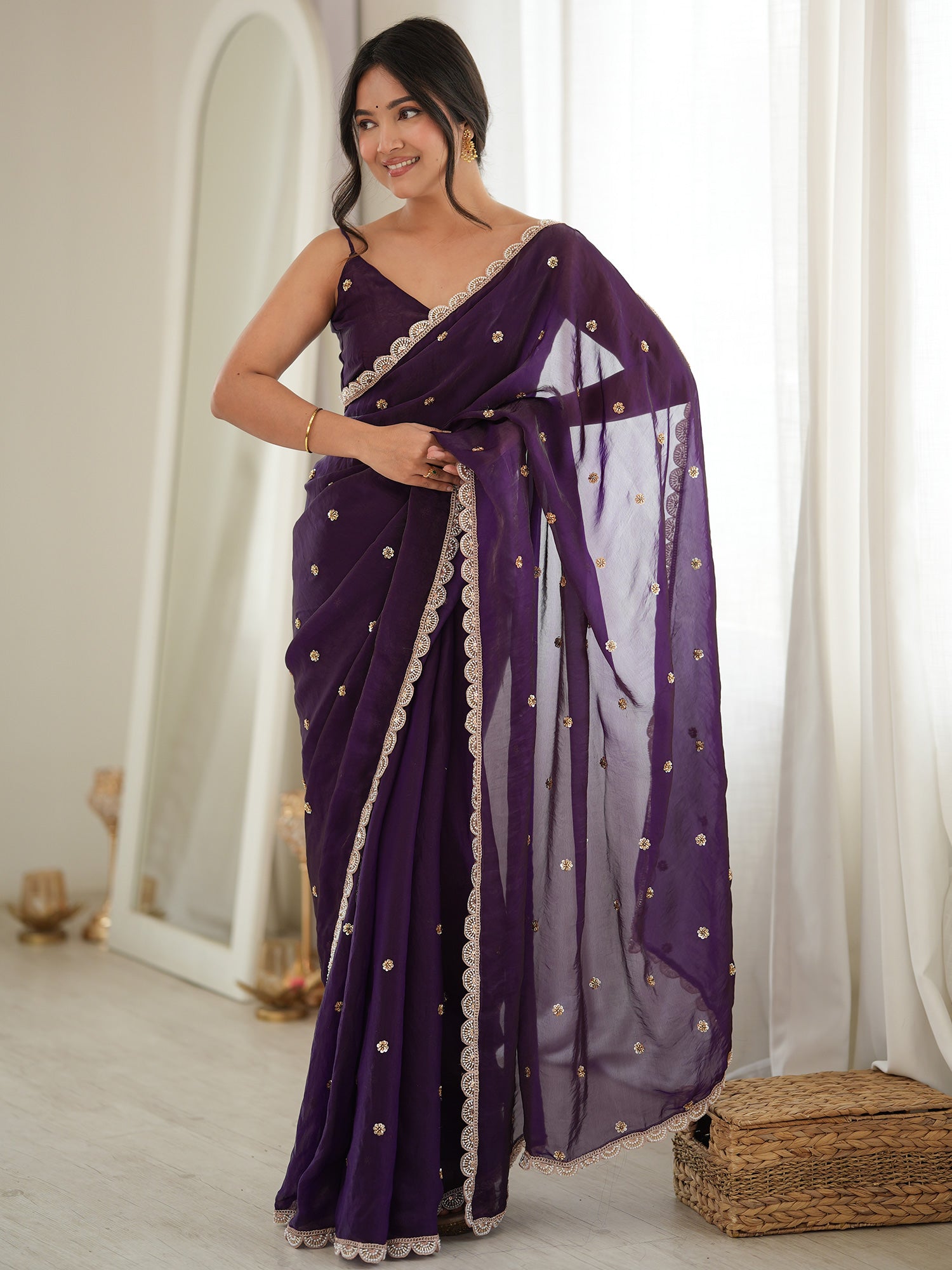 Woman wearing purple satin saree with ornamented surface design and purple blouse