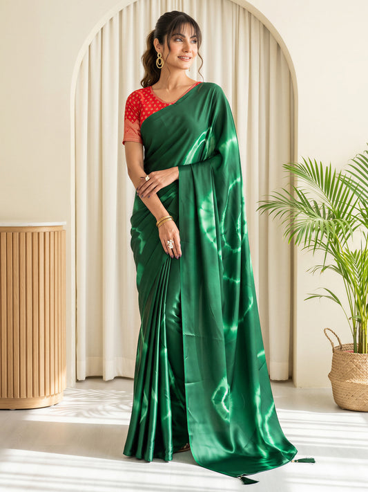 Woman wearing green satin silk saree with tie-and-dye resist pattern and red blouse