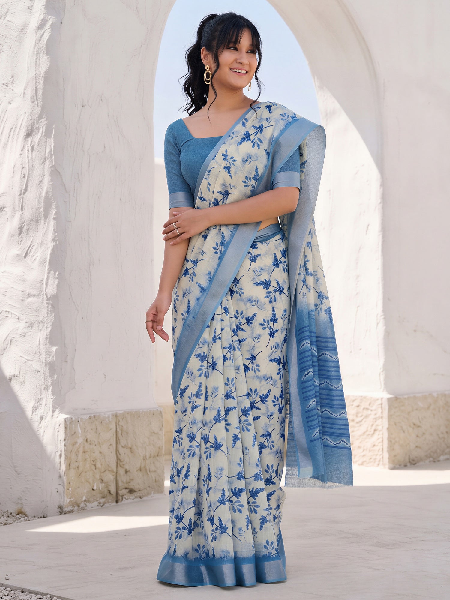 Woman wearing off white cotton linen saree with botanical floral and leaf design and blue blouse