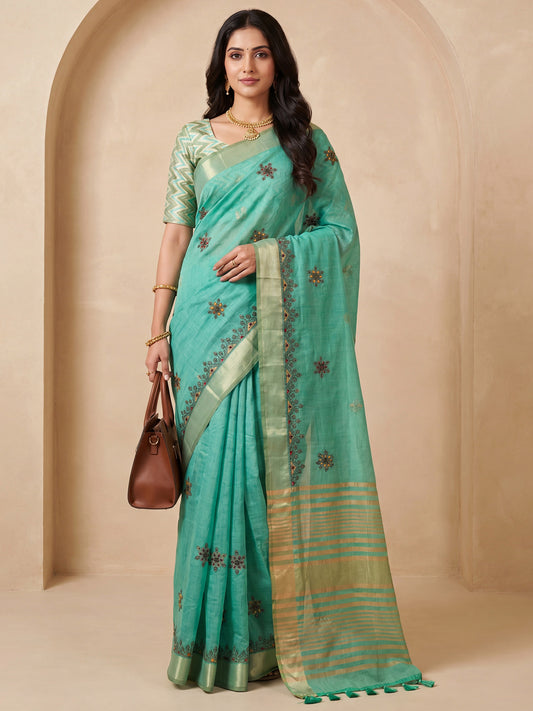 Woman wearing sea green cotton linen saree with embroidered motif work and sea green blouse
