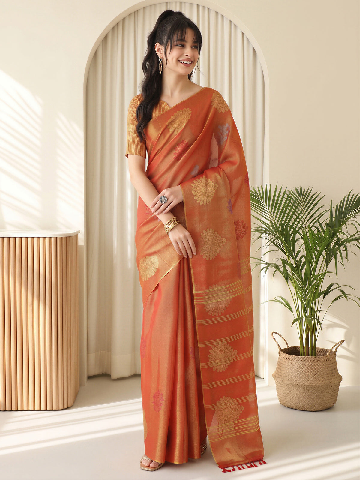 Woman wearing rust linen saree with traditional indian motif work and rust blouse