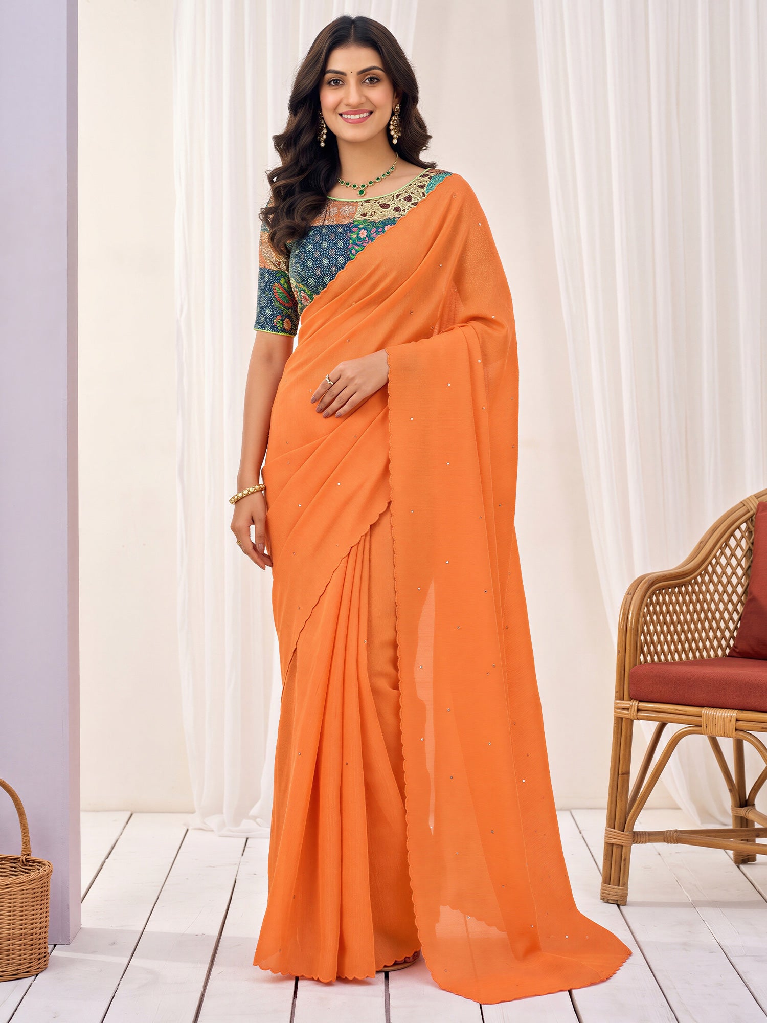 Woman wearing orange cotton saree with embroidered motif work and multicolored blouse