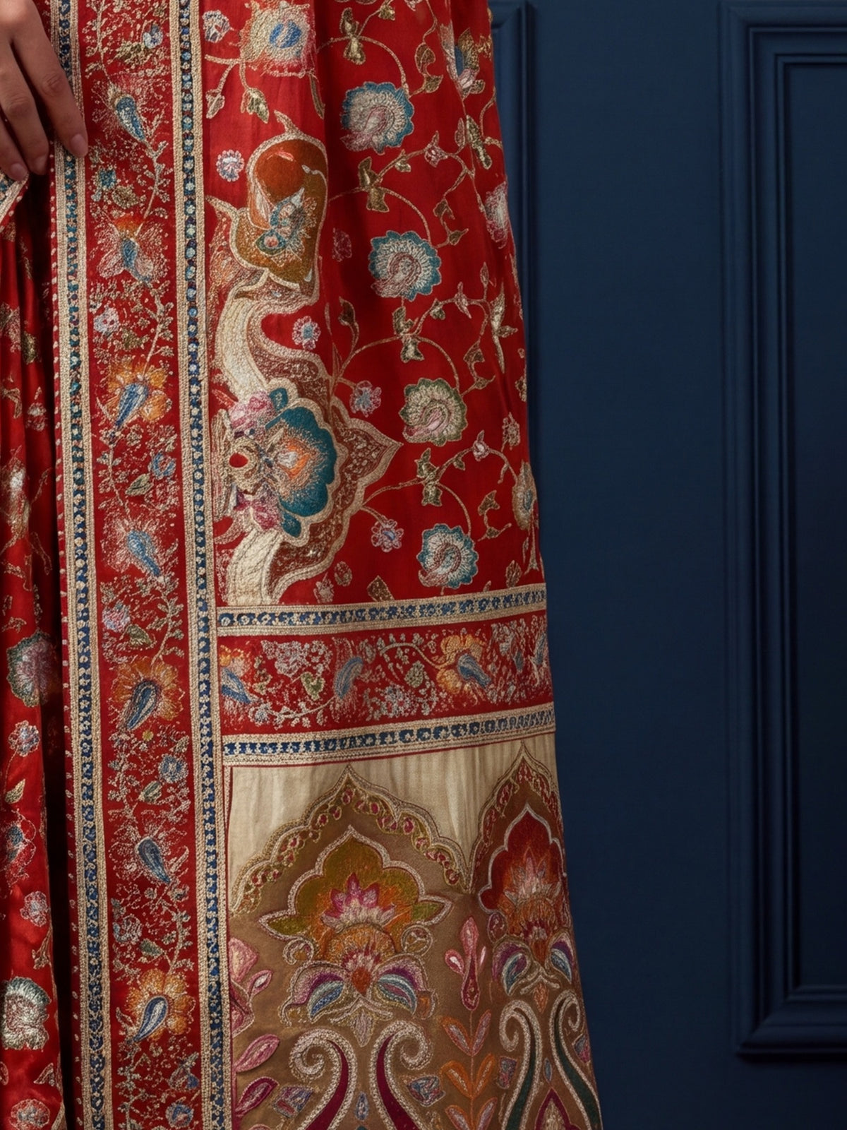 Pallu detail of orange silk blend saree showing traditional indian motif work and embellished border