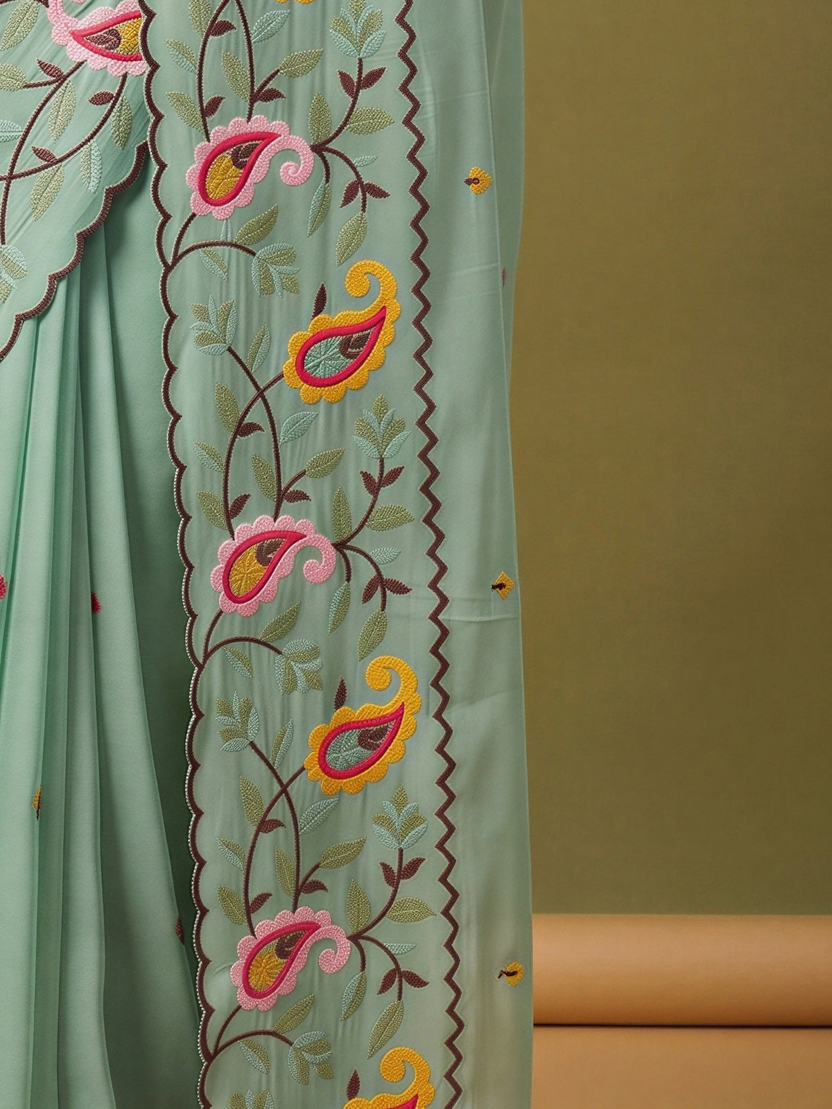 Pallu detail of light blue georgette saree showing embroidered motif work and embroidered border