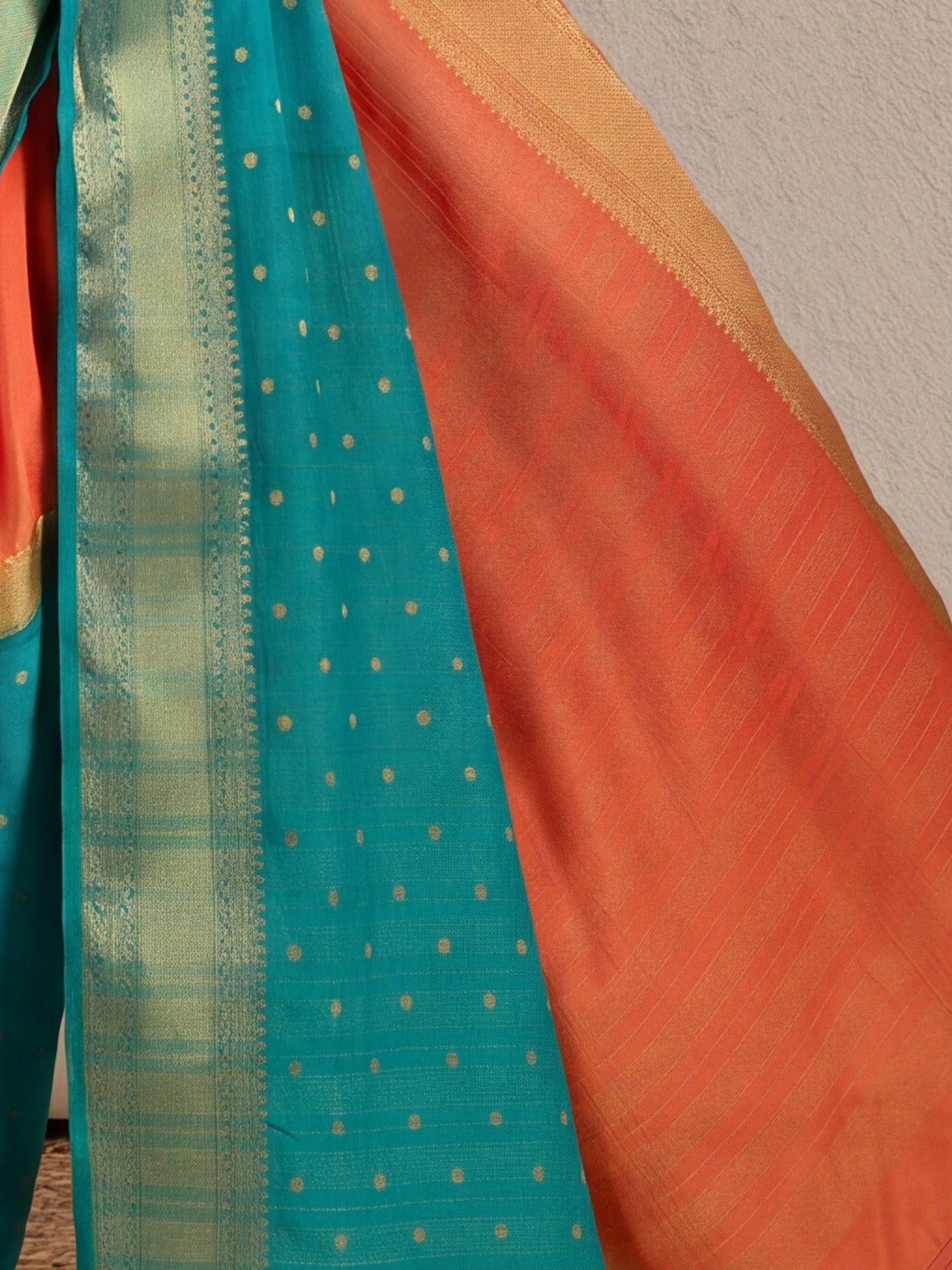 Pallu detail of orange mysore silk saree showing zari butta (metallic motif) work and zari border