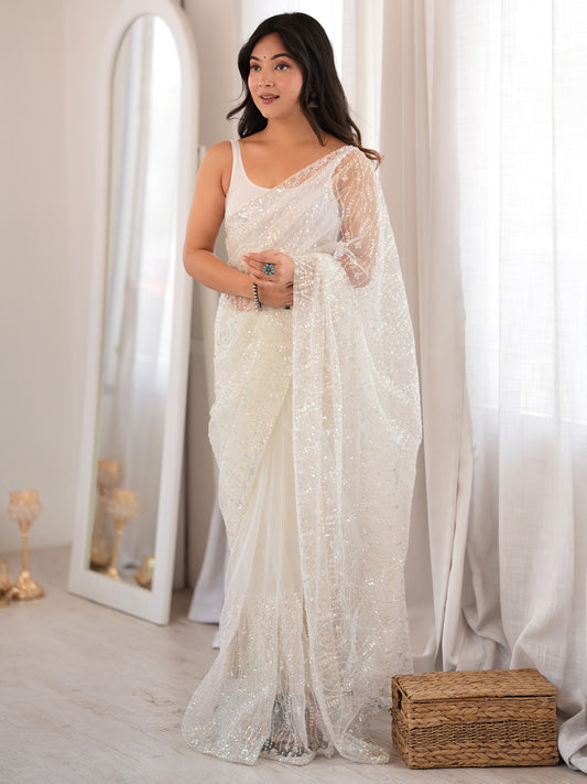 Woman wearing white net saree with ornamented surface design and white blouse