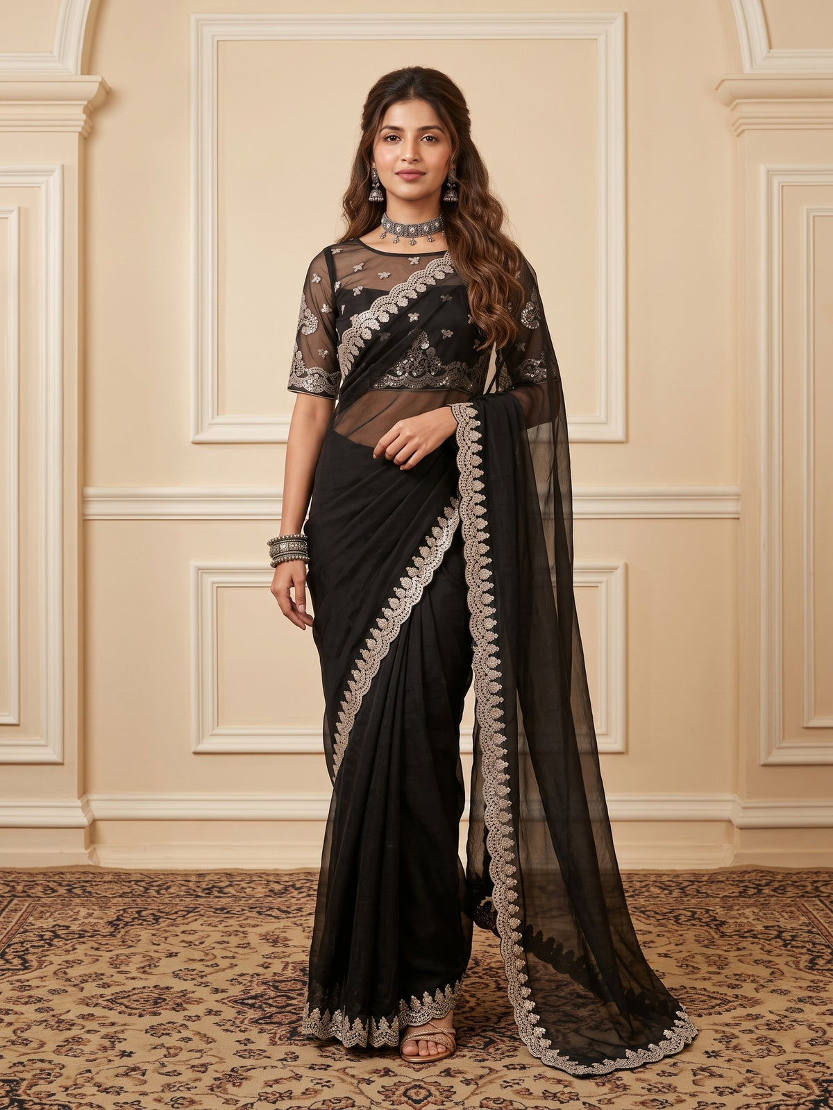 Woman wearing black satin saree with ornamented surface design and black blouse