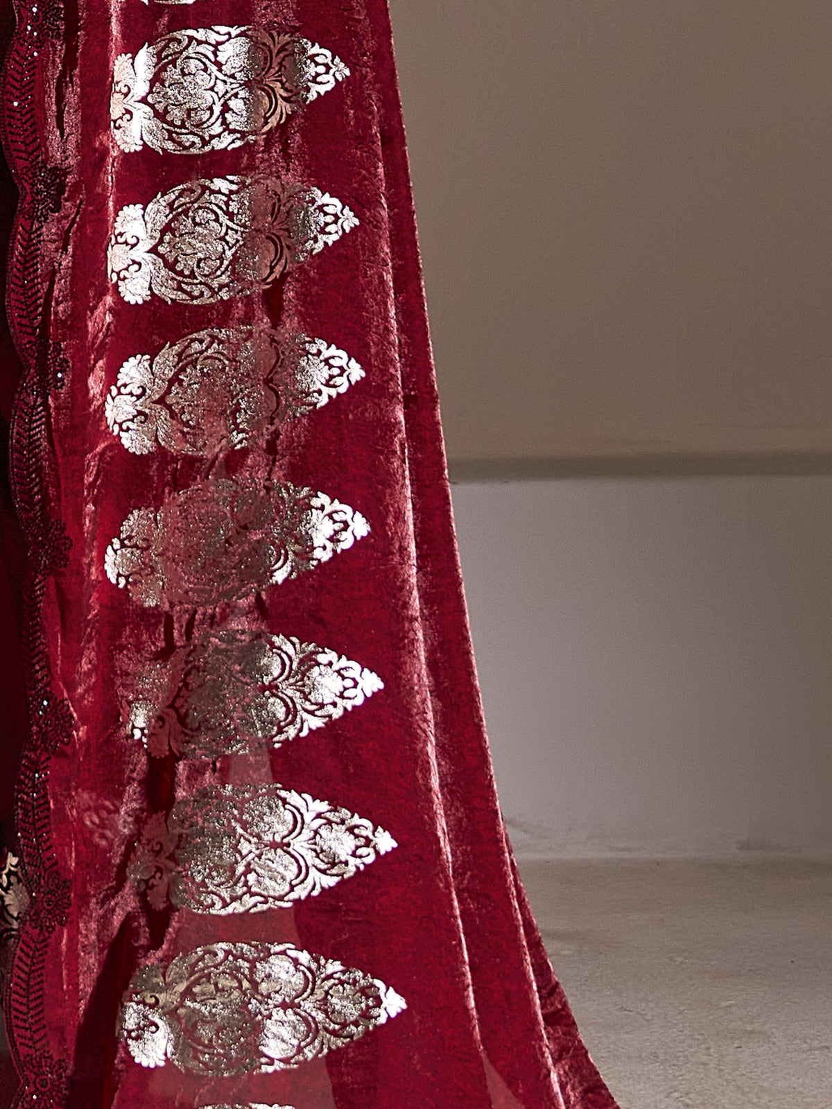 Pallu detail of maroon satin silk saree showing metallic foil print work and embellished border