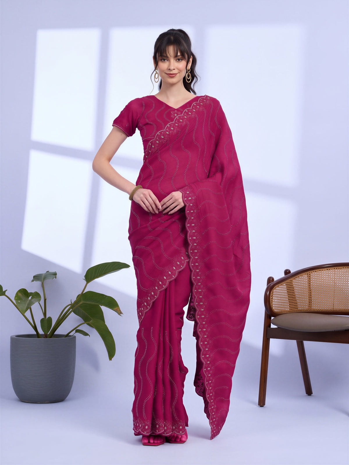 Woman wearing pink tissue saree with geometric pattern design and pink blouse