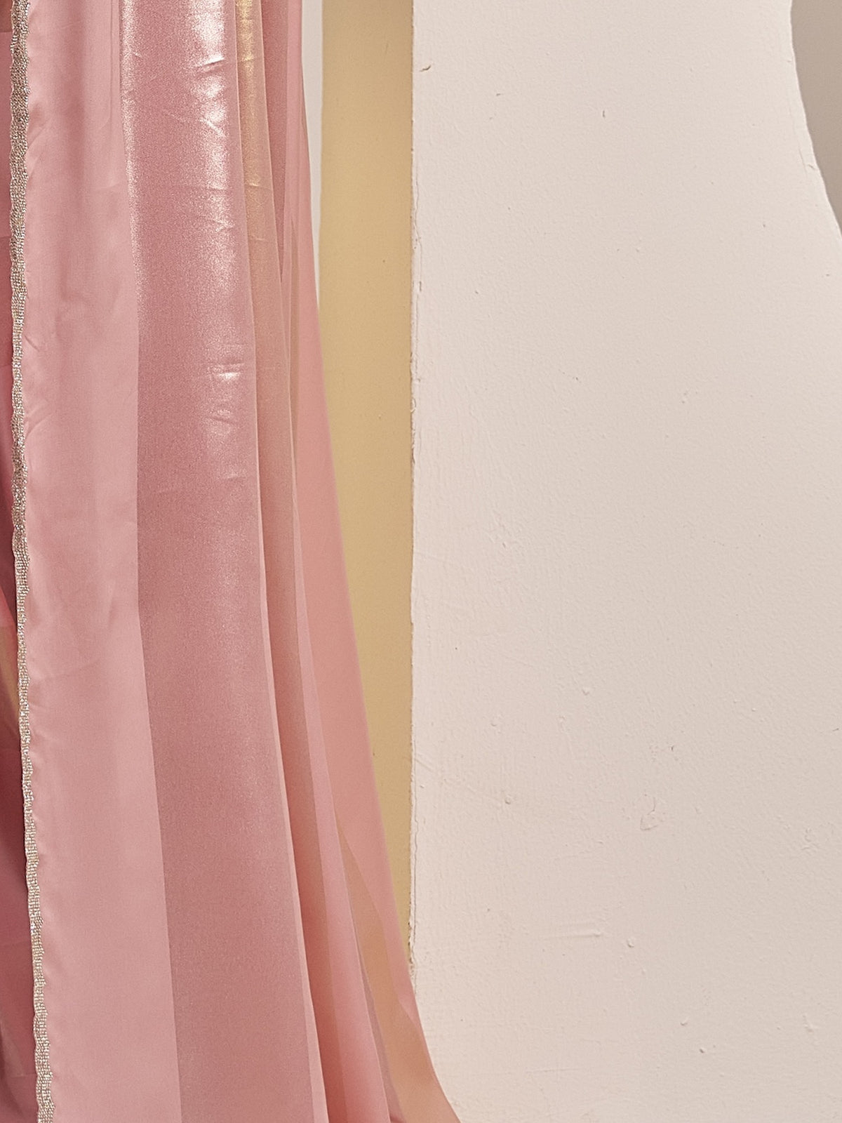 Pallu detail of peach satin silk saree showing metallic foil print work and embellished border