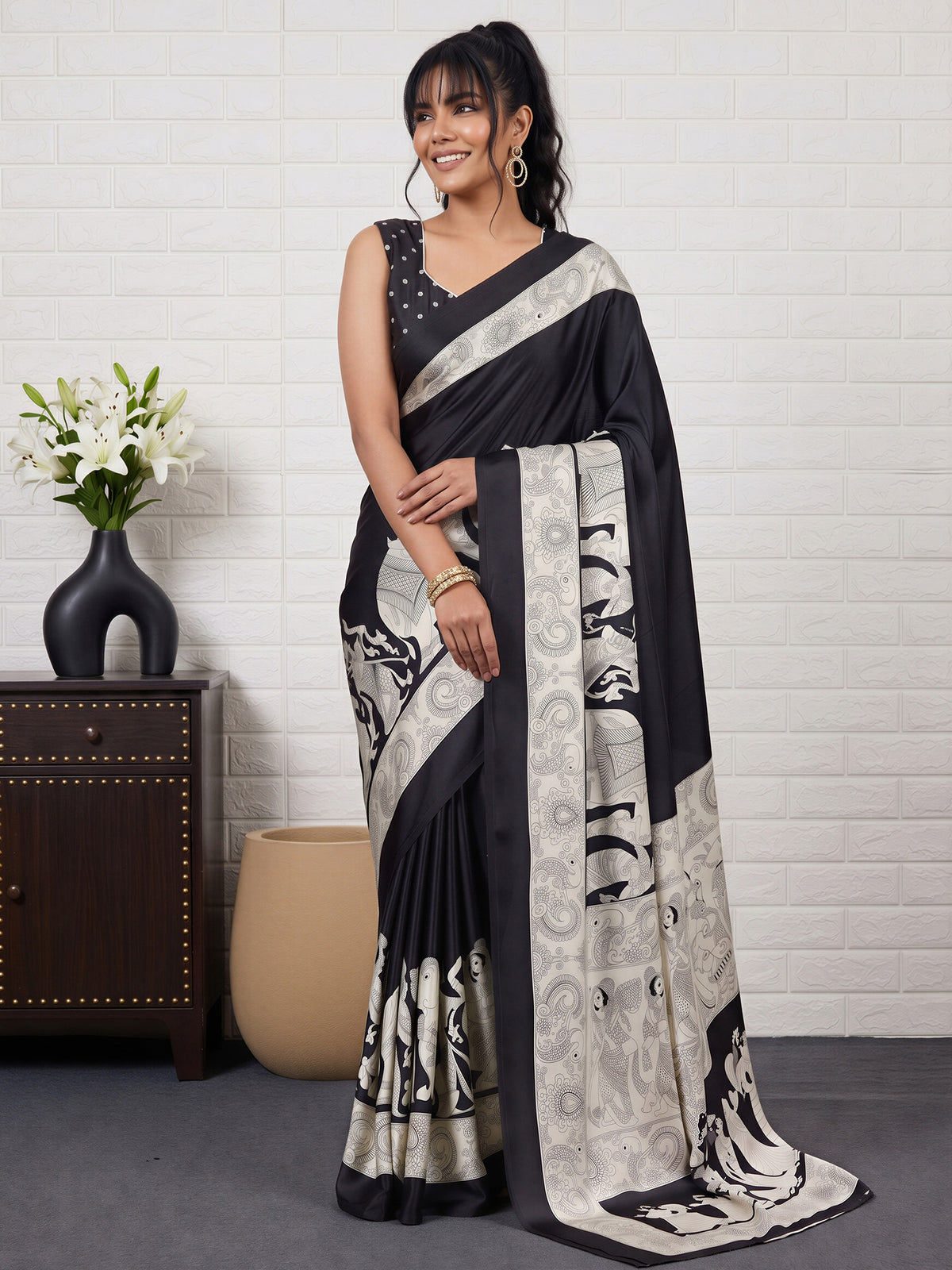 Woman wearing black satin saree with kalamkari narrative motif work and black blouse