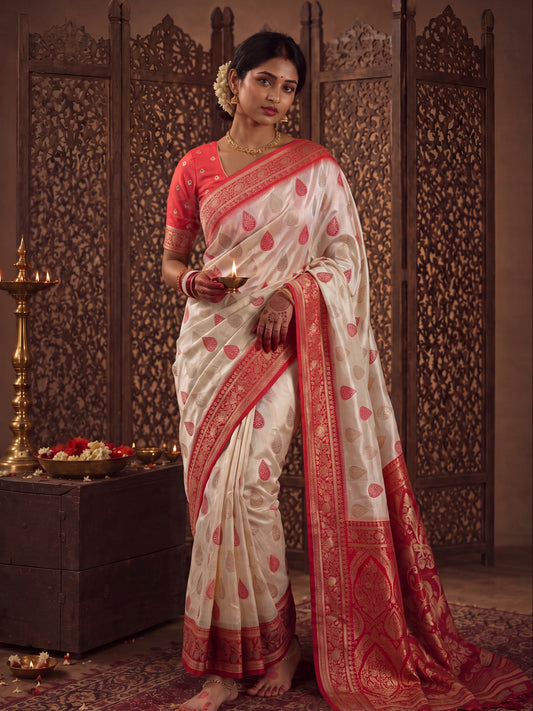 Woman wearing white banarasi silk saree with zari butta (metallic motif) work and red blouse