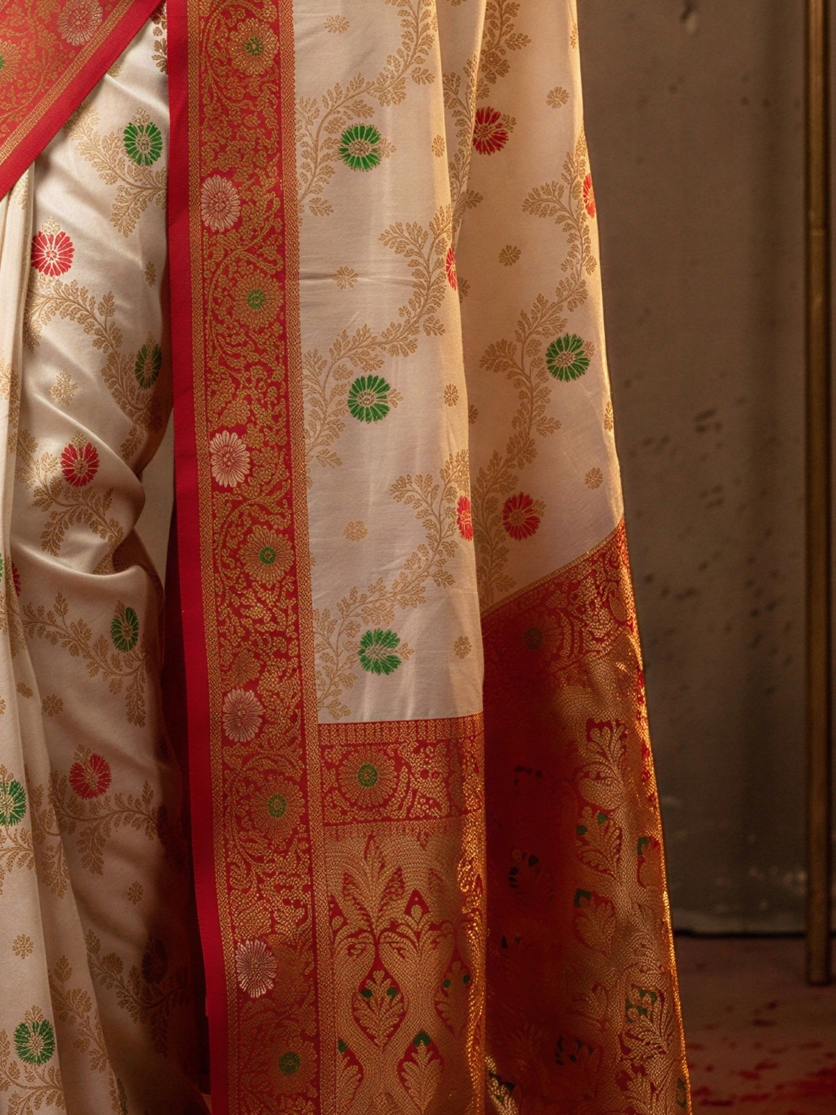 Pallu detail of white banarasi silk saree showing zari butta (metallic motif) work and zari border