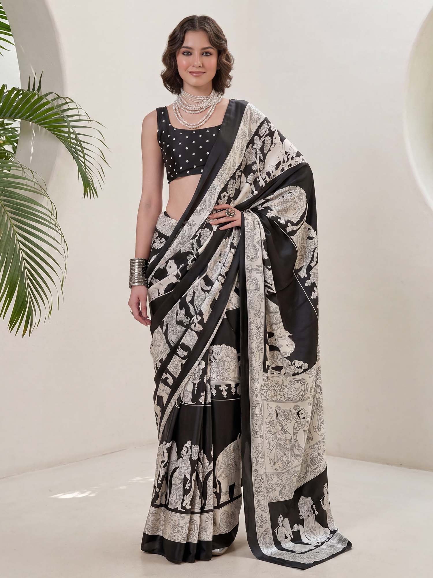 Woman wearing black crepe saree with kalamkari narrative motif work and black blouse